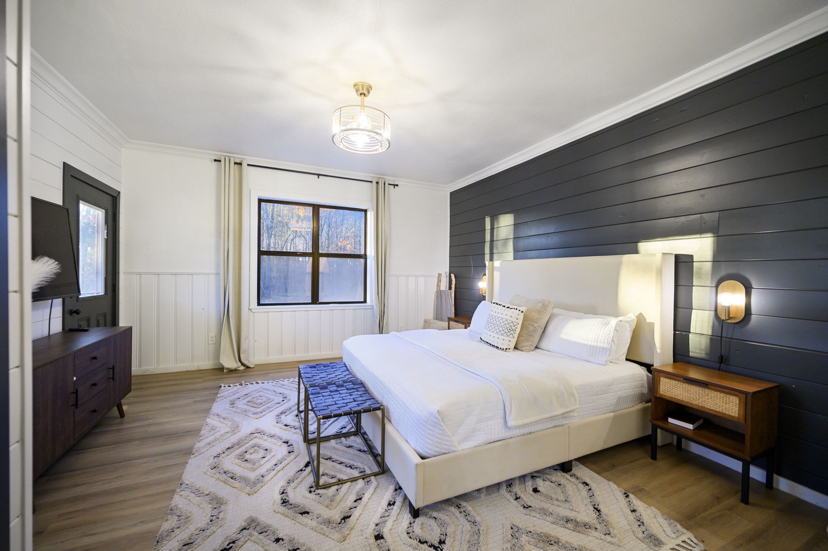 Unwind in your serene bedroom with plush white bedding, cozy textures, and warm lighting creating the perfect retreat.