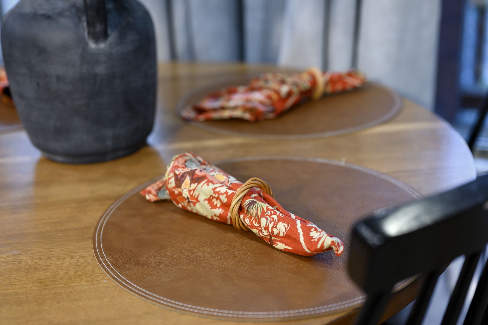 Stylish table setting awaits you with beautiful burnt-orange patterned napkins and thoughtful place settings that create an inviting atmosphere for your meals.