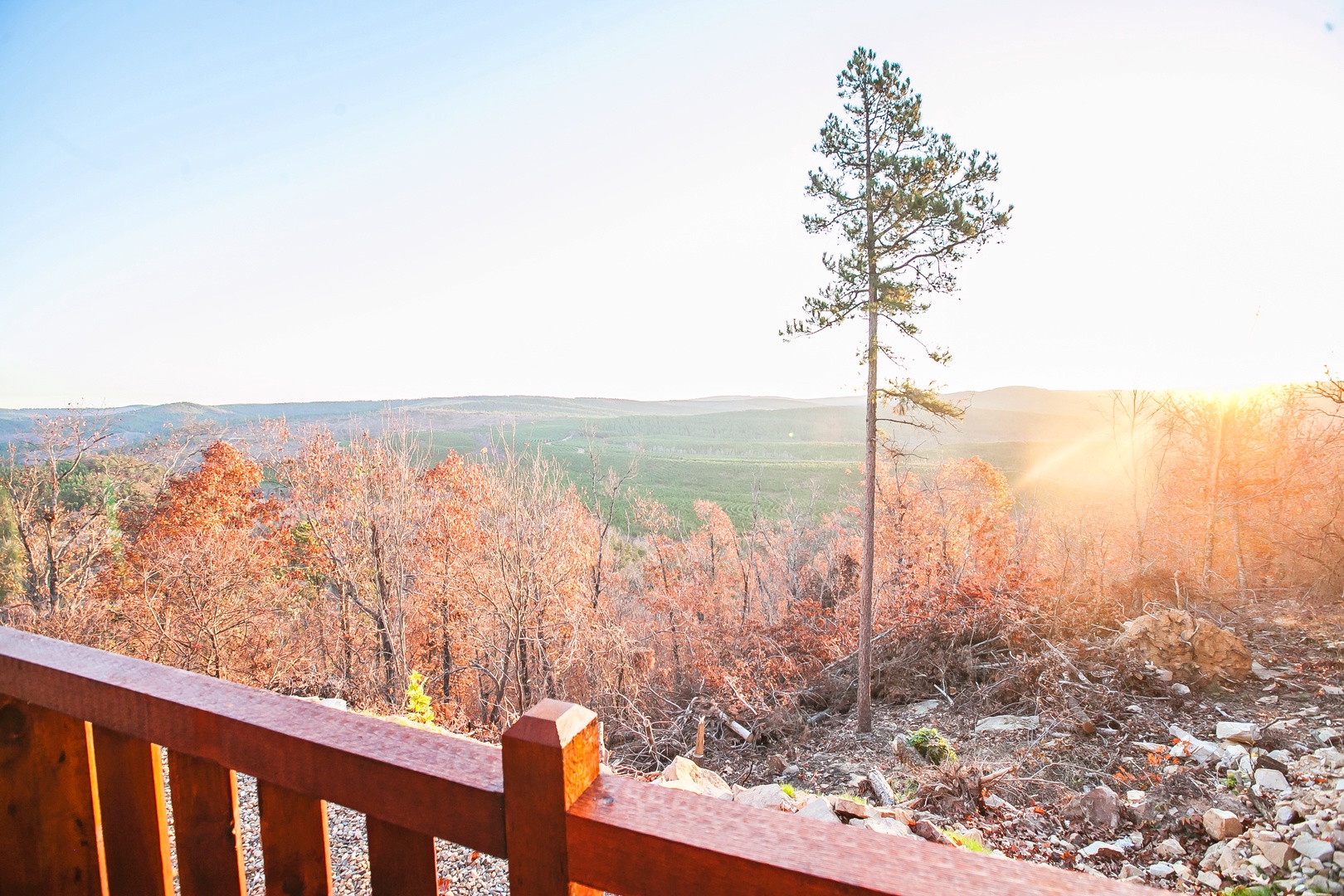 Stunning autumn landscape with vibrant fall foliage stretching across rolling hills, captured during golden hour from the property deck.