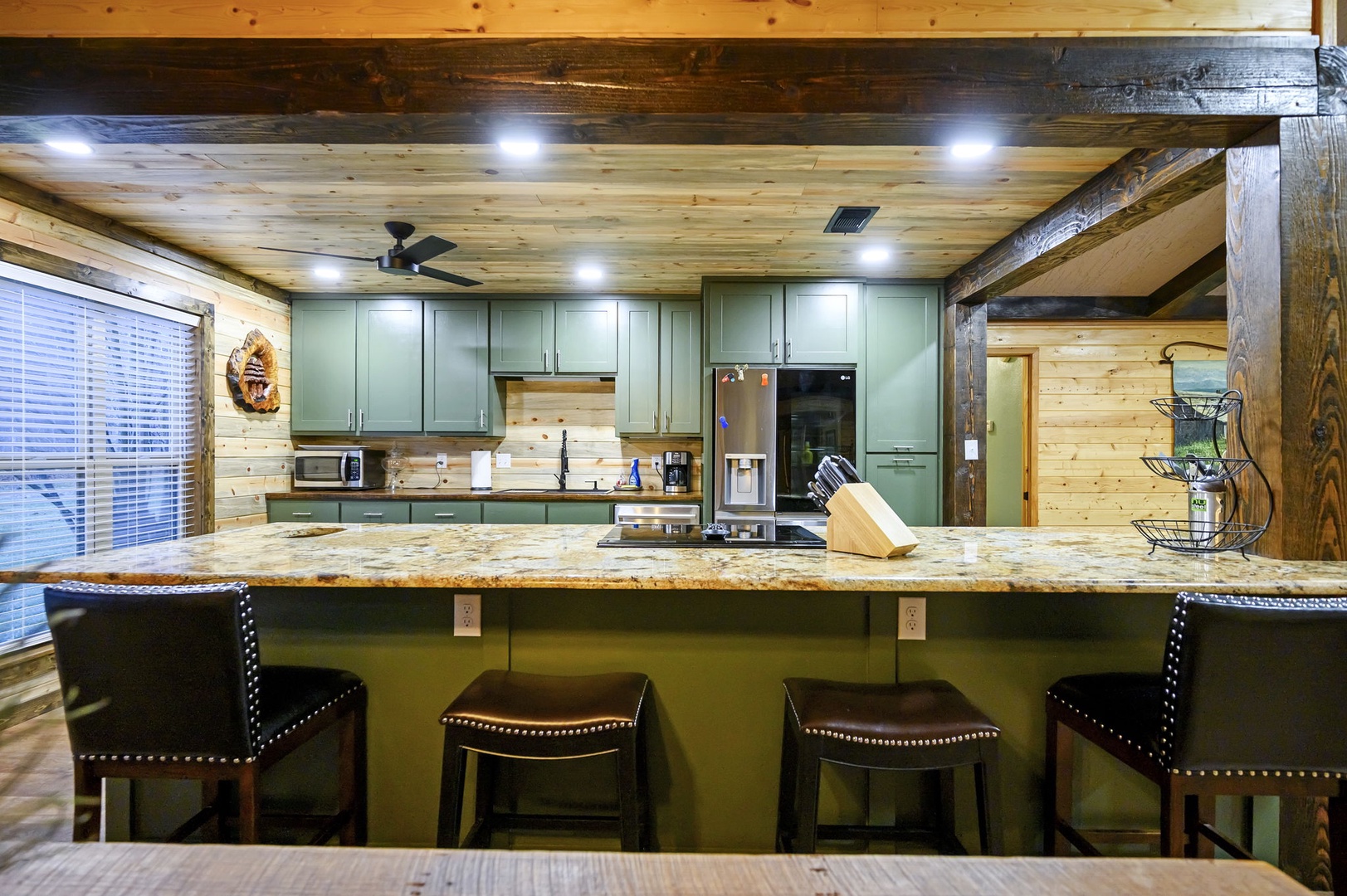 Your fully equipped kitchen features granite countertops and rustic wood beams, perfect for preparing meals together during your mountain getaway.