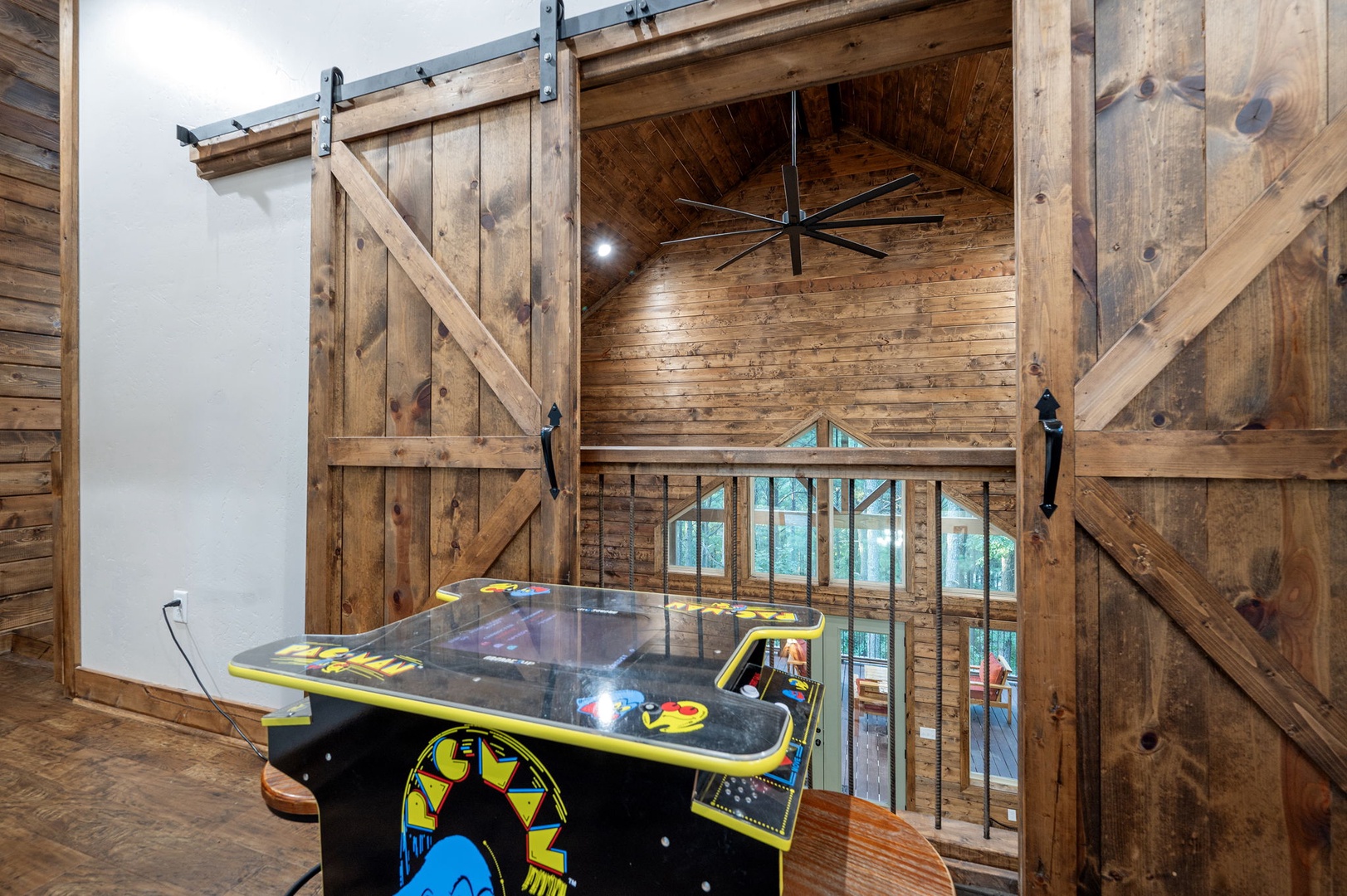 Challenge your friends to a Pac-Man showdown in this rustic game loft with soaring wood-paneled ceilings and views of the main floor below.