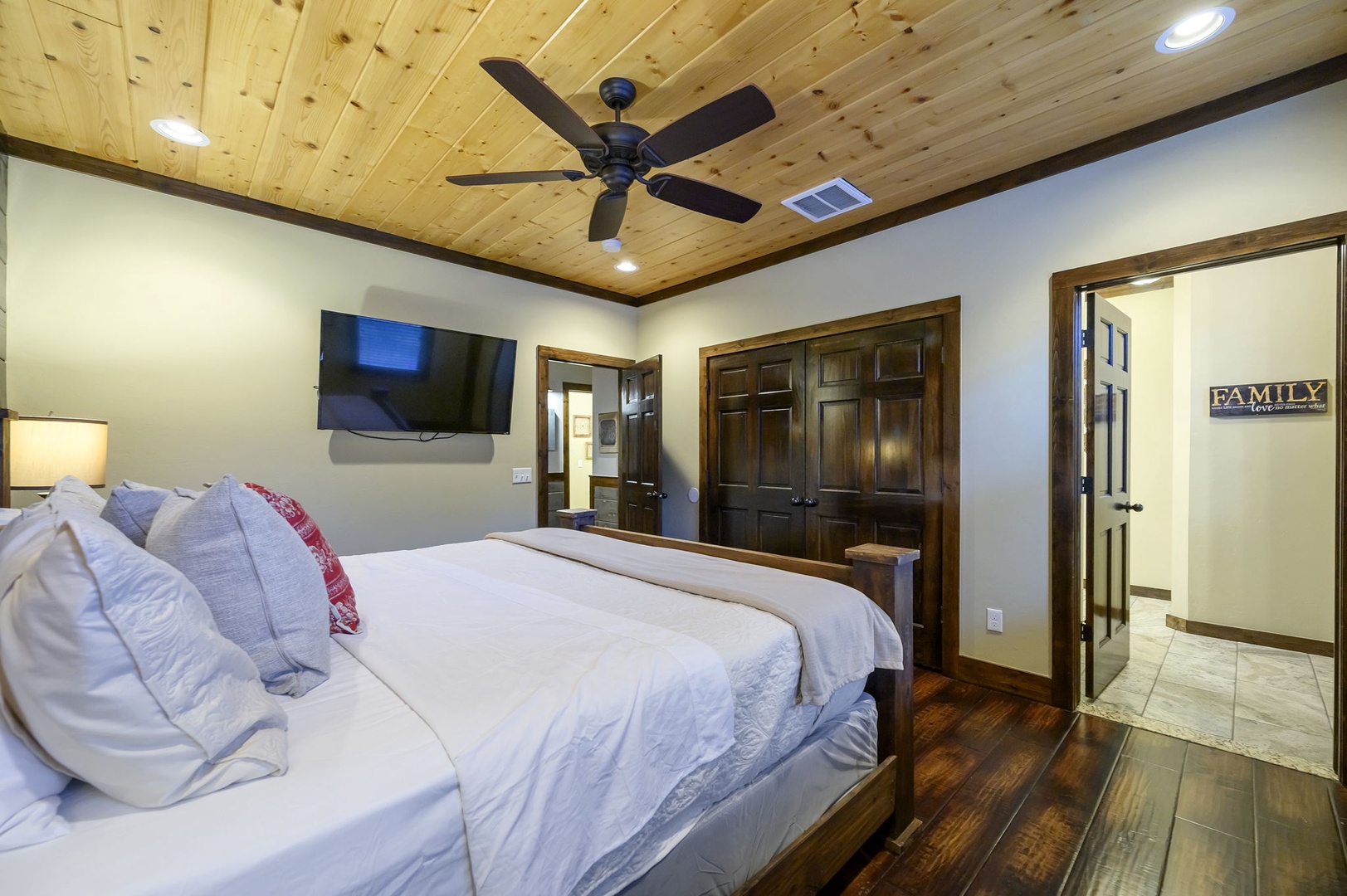 Settle into this spacious bedroom with its plush king bed and stylish wood-paneled ceiling. Your private retreat offers modern comfort, including a flat-screen TV for unwinding after your adventures.