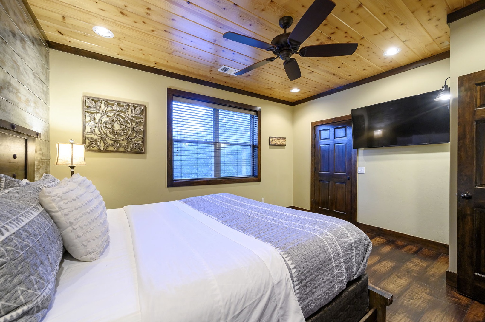 Settle into crisp linens under a beautiful wood-planked ceiling with a ceiling fan keeping you cool. Natural light streams through the window while your favorite shows await on the flat-screen TV.