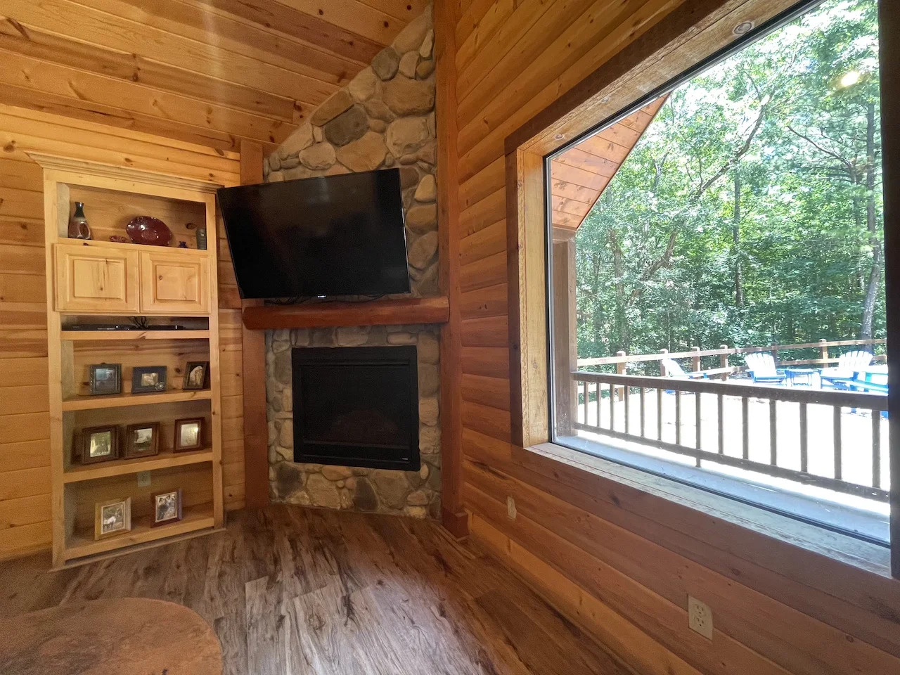 Sink into the warmth of the stone fireplace while enjoying your forest view through expansive windows overlooking the private deck and pool beyond.