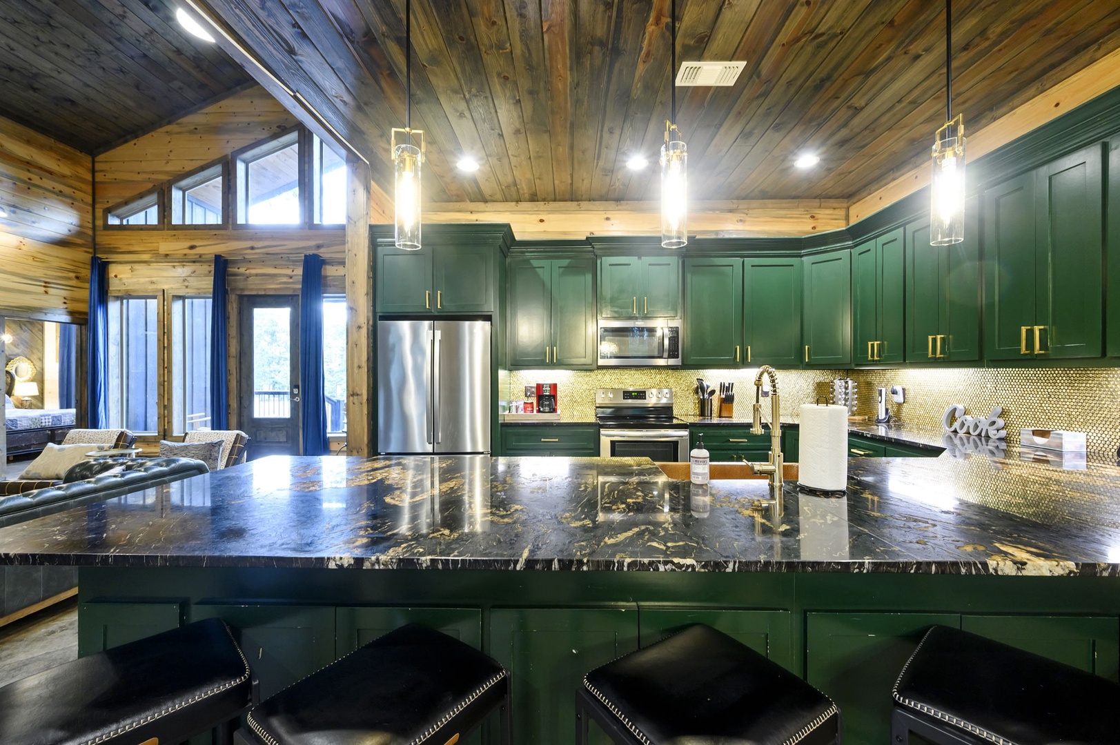 Dream mountain retreat with soaring wood ceilings, emerald kitchen, and gleaming granite island. Top-tier appliances and floor-to-ceiling windows create the perfect gathering space for memorable evenings.