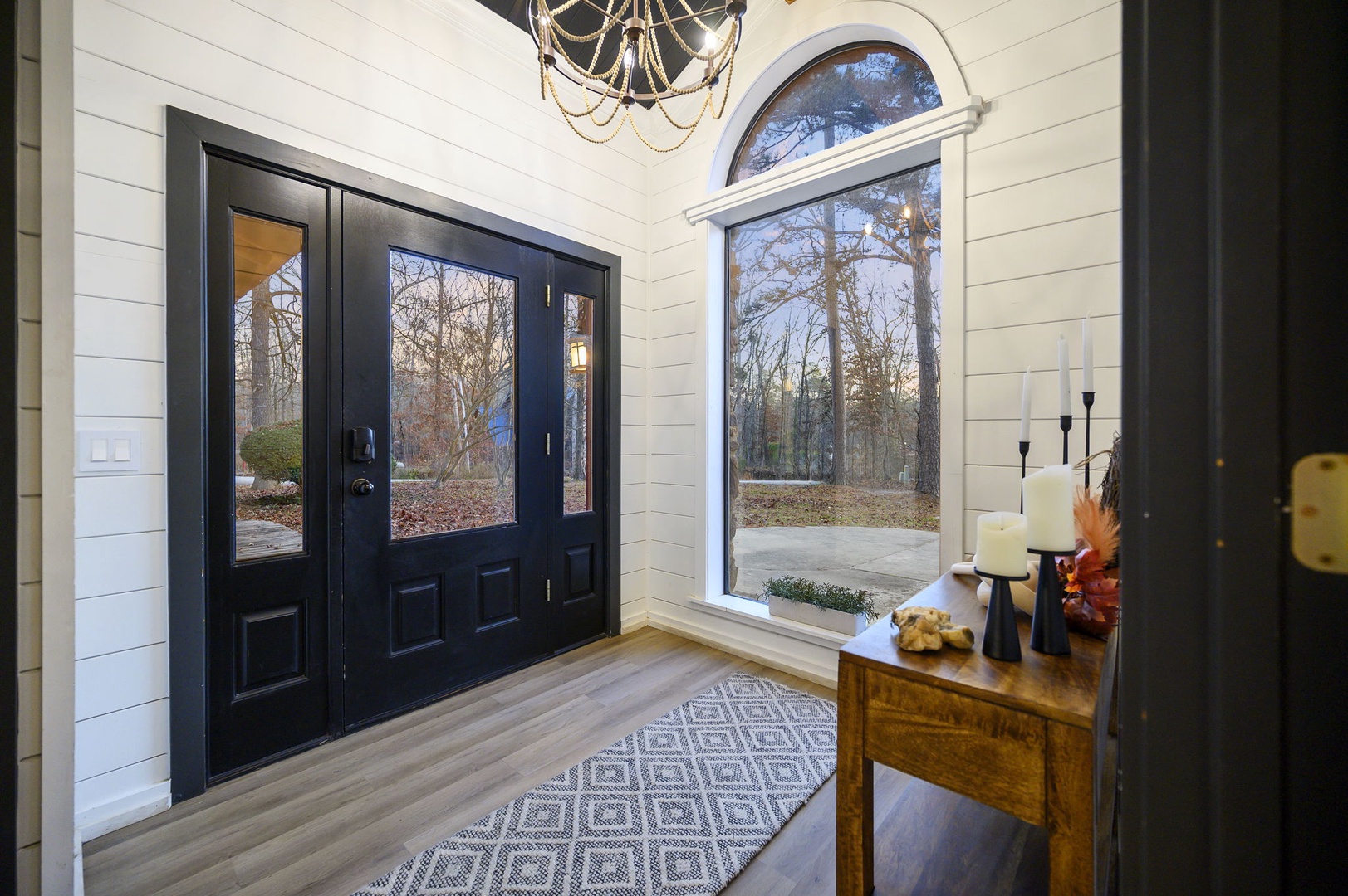 Step into your elegant entryway with soaring ceilings, gorgeous shiplap walls, and beautiful natural light streaming through arched windows.