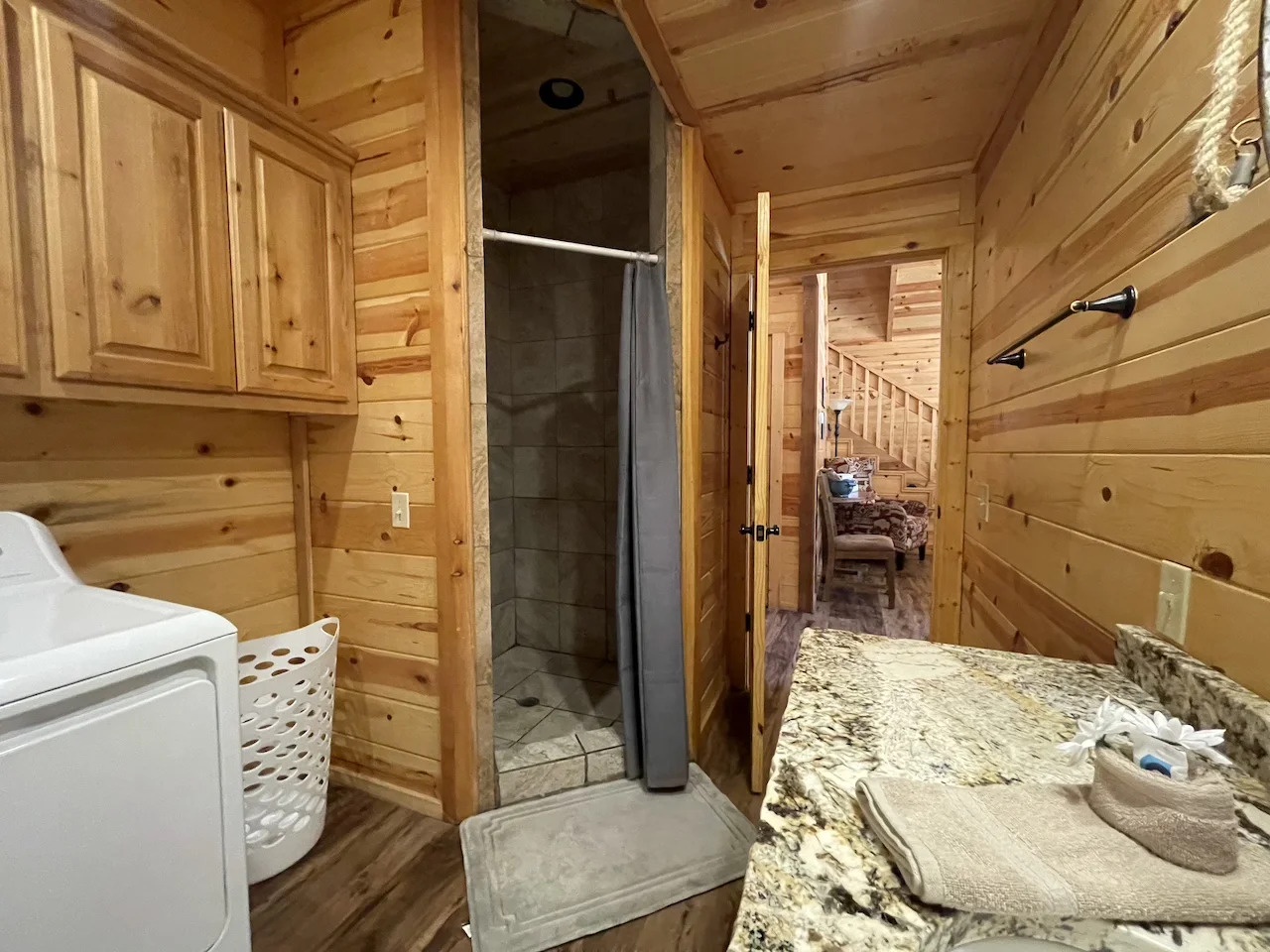Your private bathroom features natural wood warmth, a modern tiled shower, granite counter, and convenient laundry—perfect for refreshing after mountain adventures.