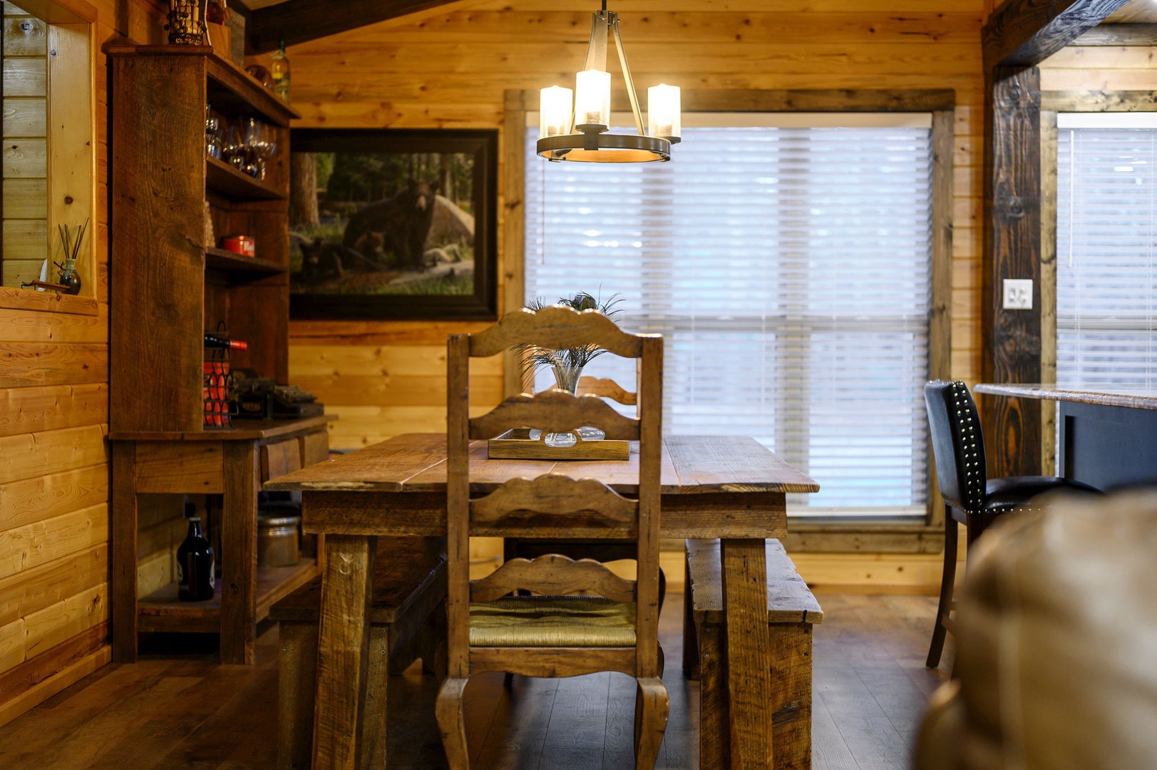 Gather around your rustic dining table where warm wood tones and soft lighting create the perfect atmosphere for memorable meals together.