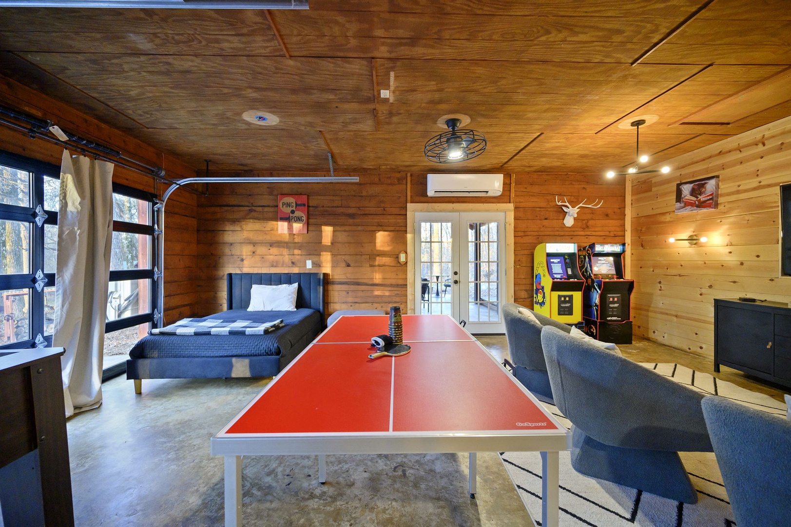 Your game room features ping pong, arcade games, and cozy seating in warm wood surroundings—perfect for fun evenings with friends.