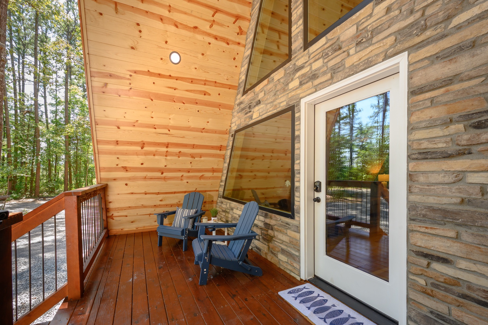 Step onto your private covered deck, where Adirondack chairs invite you to unwind surrounded by towering pines and the peaceful sounds of the forest.