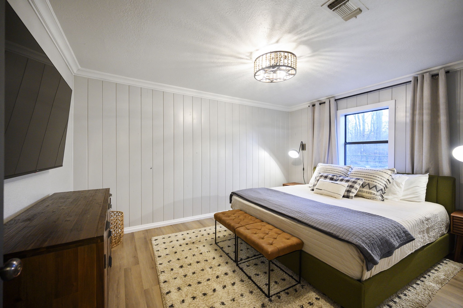 Slip into crisp linens beneath elegant lighting, where modern comfort meets rustic charm in your peaceful retreat.