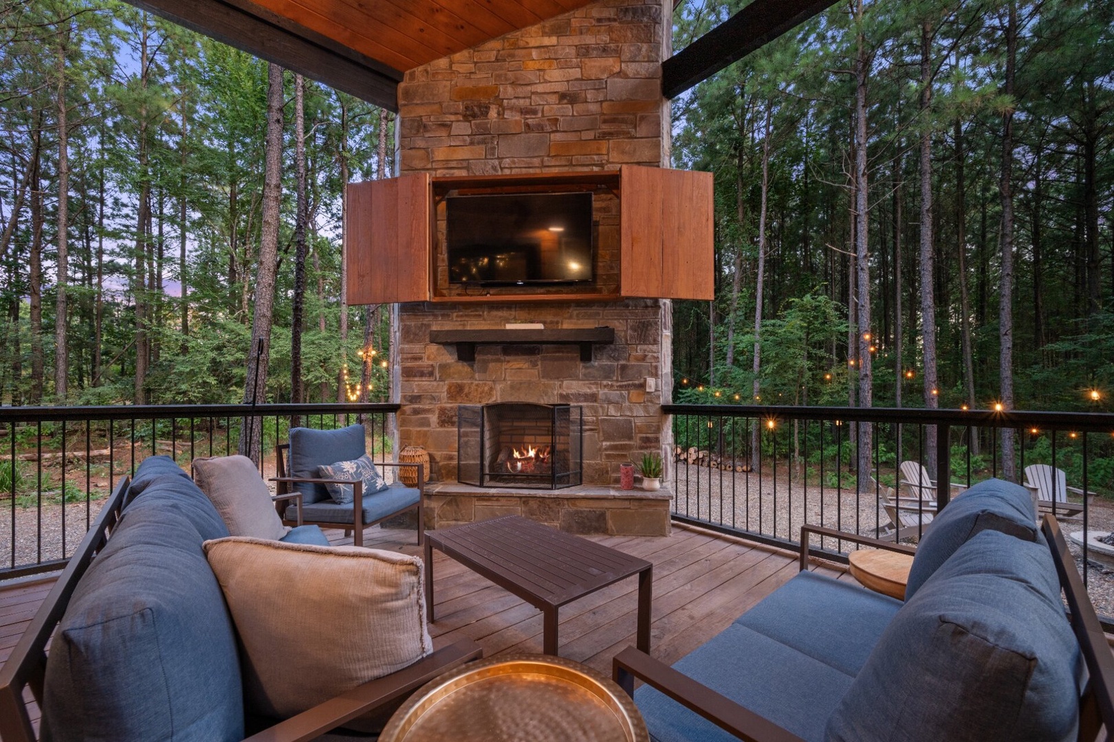 Gather around your private outdoor fireplace on this covered deck, surrounded by towering pines and the peaceful sounds of the forest—perfect for cozy evenings under the stars.