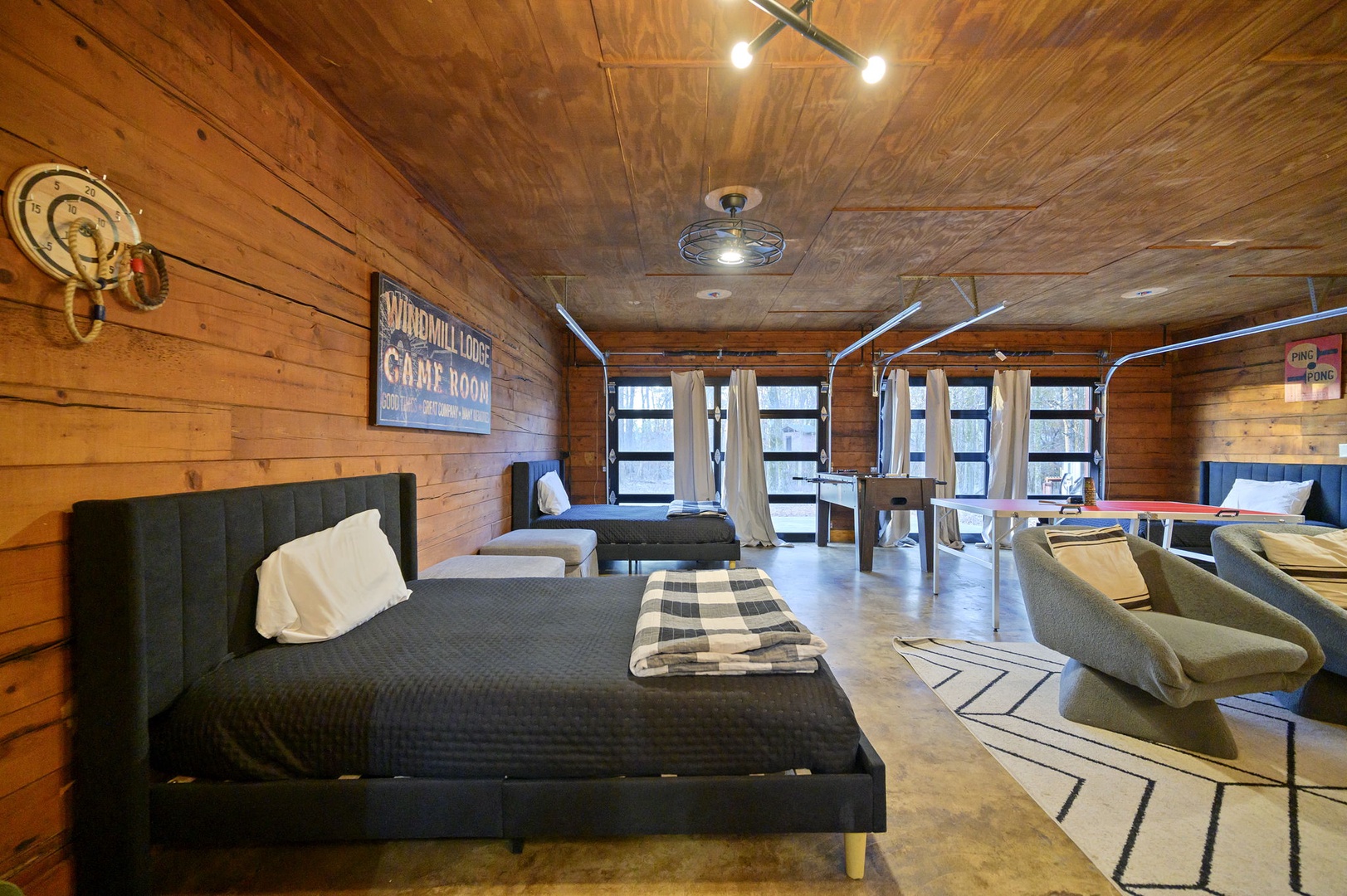 Unwind in your rustic retreat featuring warm wood walls, modern furnishings, and gaming tables for memorable evenings with loved ones.