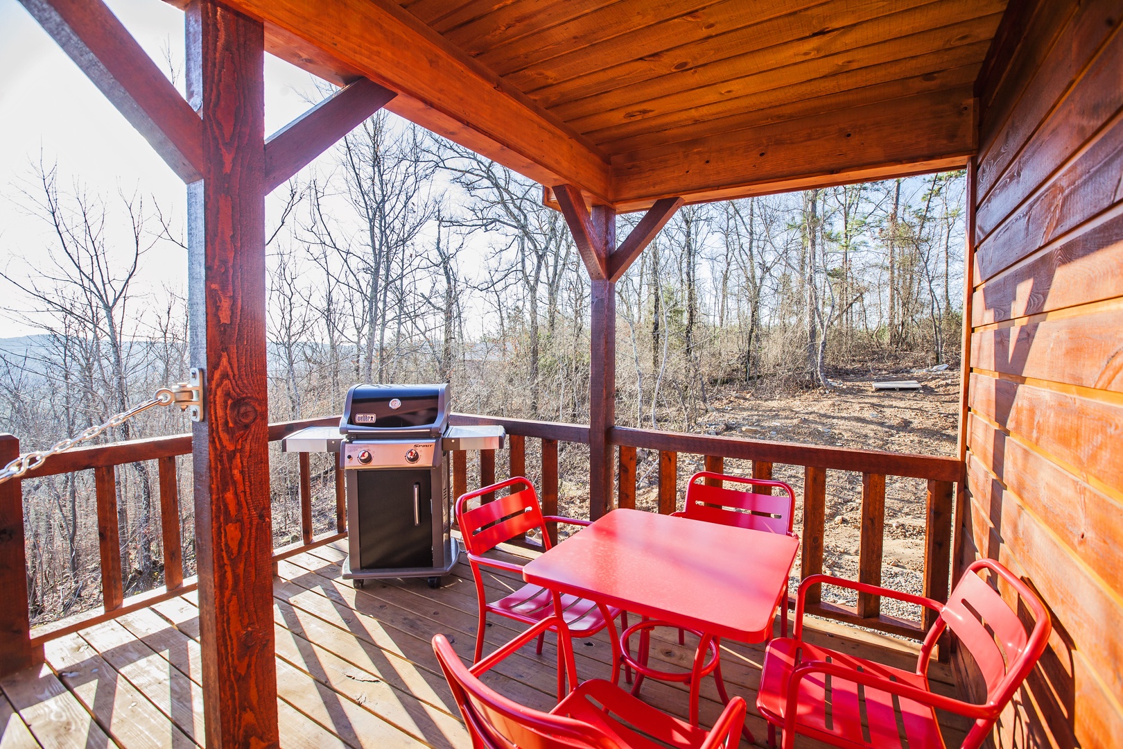 Your private deck offers mountain views with a BBQ grill and bright red dining set for memorable outdoor meals.