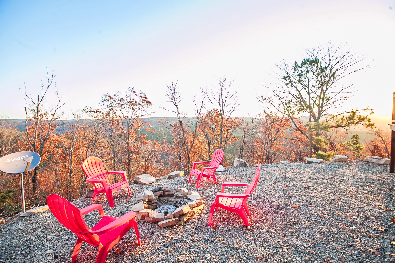 Gather around your private fire pit with vibrant red Adirondack chairs, surrounded by stunning autumn foliage and mountain views.