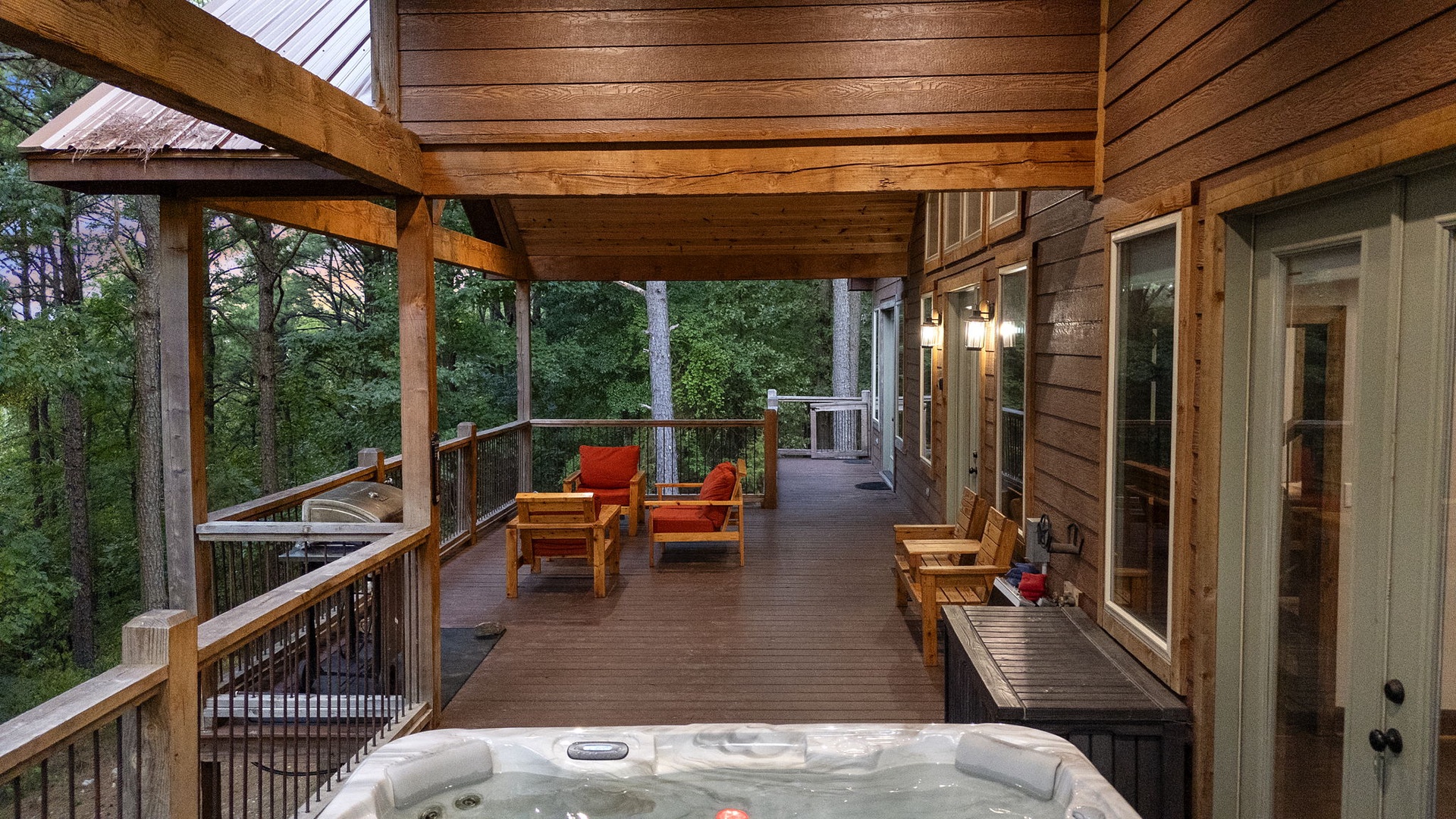Unwind on your private deck with cozy seating, a bubbling hot tub, and serene forest views—your perfect retreat after a day of adventure.