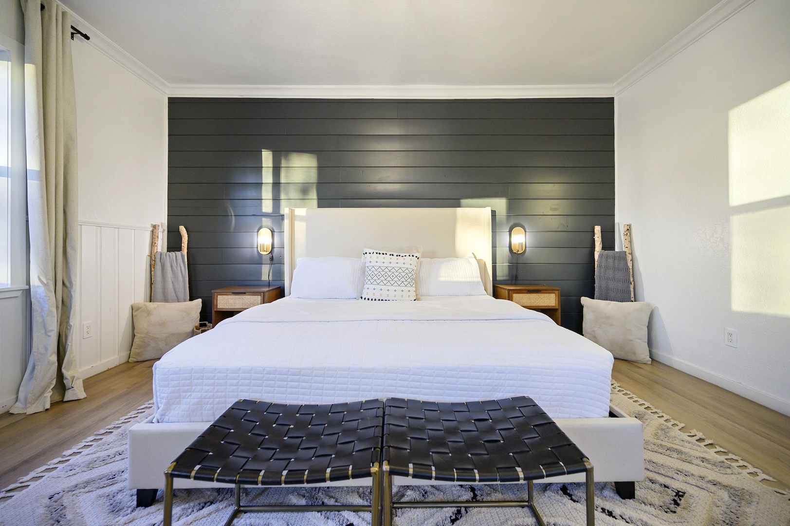 Sink into crisp white linens and unwind in your serene bedroom, where warm wood accents and soft lighting create the perfect retreat.