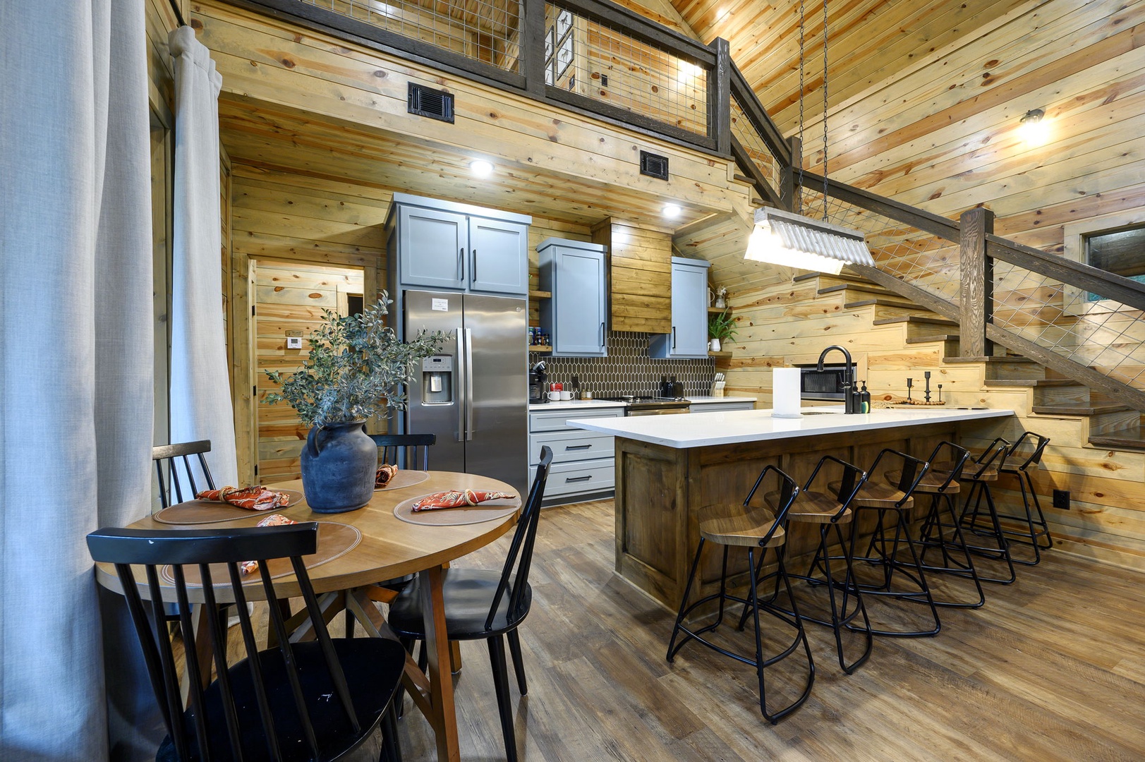 Gather around the spacious kitchen island or enjoy meals at the cozy dining table beneath soaring wood ceilings and rustic beams—your mountain retreat awaits.