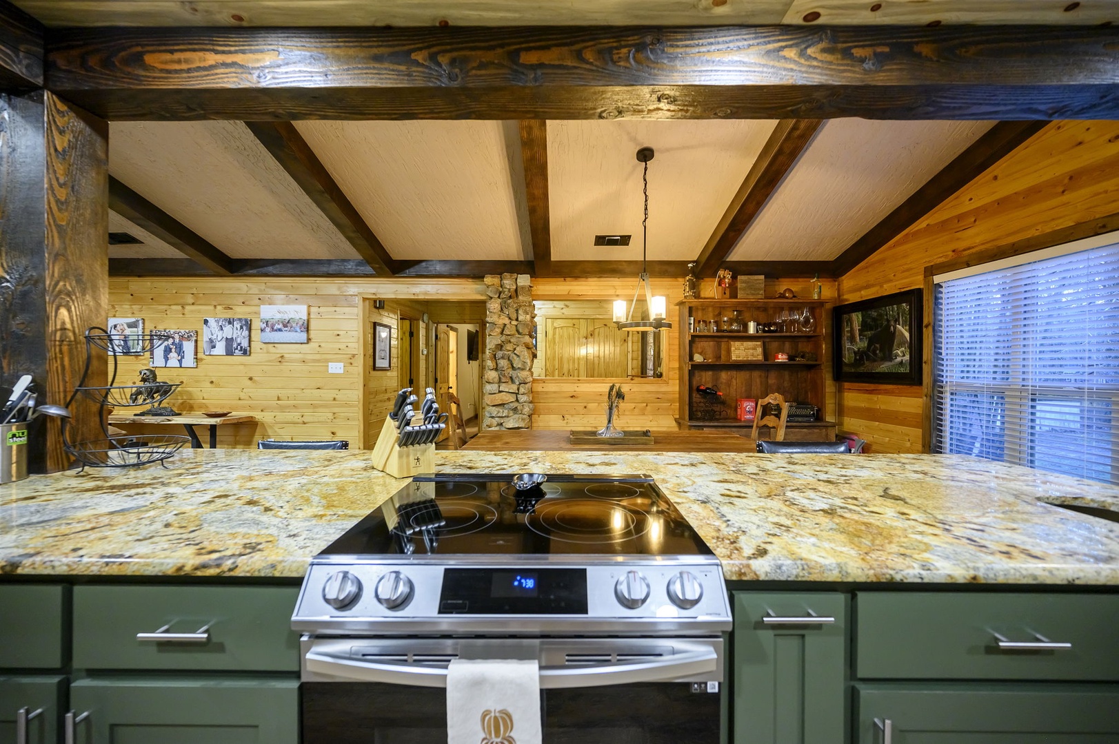 Cook in your rustic kitchen with granite counters, exposed beams, and cozy stone fireplace creating the perfect mountain retreat atmosphere. Please note that the fireplace is not available for guest use.