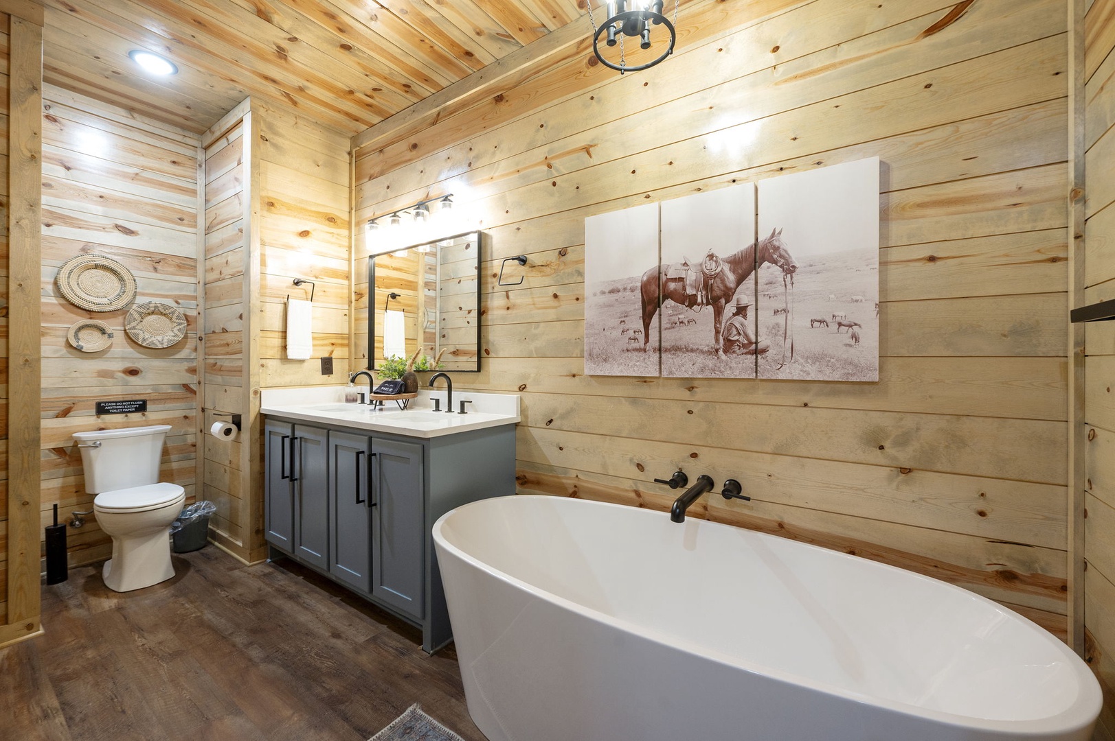 Unwind in your private bathroom featuring warm wood walls, a luxurious soaking tub, and modern double vanity—your perfect retreat after a day of adventure.