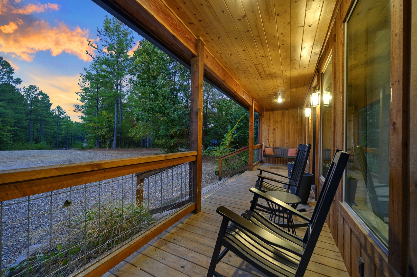 Watch the sky blaze with sunset colors from your private covered deck, where rocking chairs invite you to unwind amid peaceful wooded surroundings.