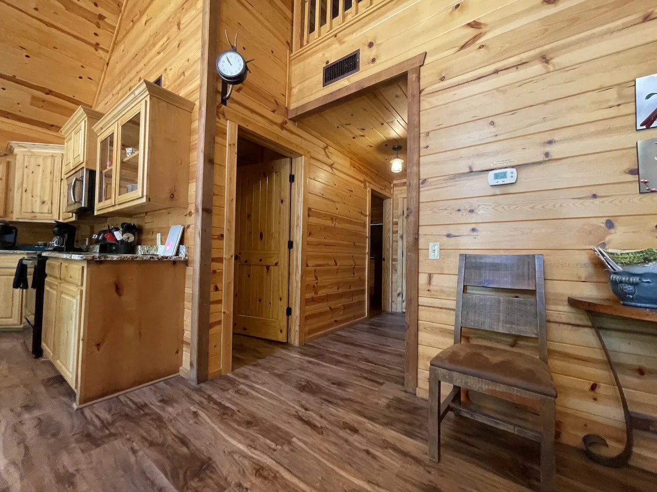 Step into the warmth of natural wood throughout this cozy cabin interior, where rustic charm meets modern comfort. Your open-plan living space connects seamlessly to the kitchen, perfect for gathering and relaxing.