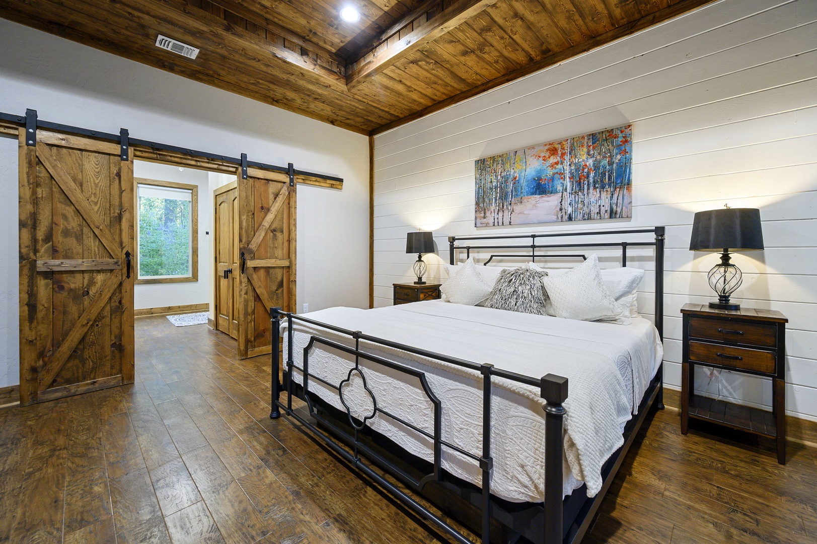 Unwind in your rustic retreat with authentic barn doors, soaring wood-beamed ceilings, and a plush bed that invites deep rest after mountain adventures.