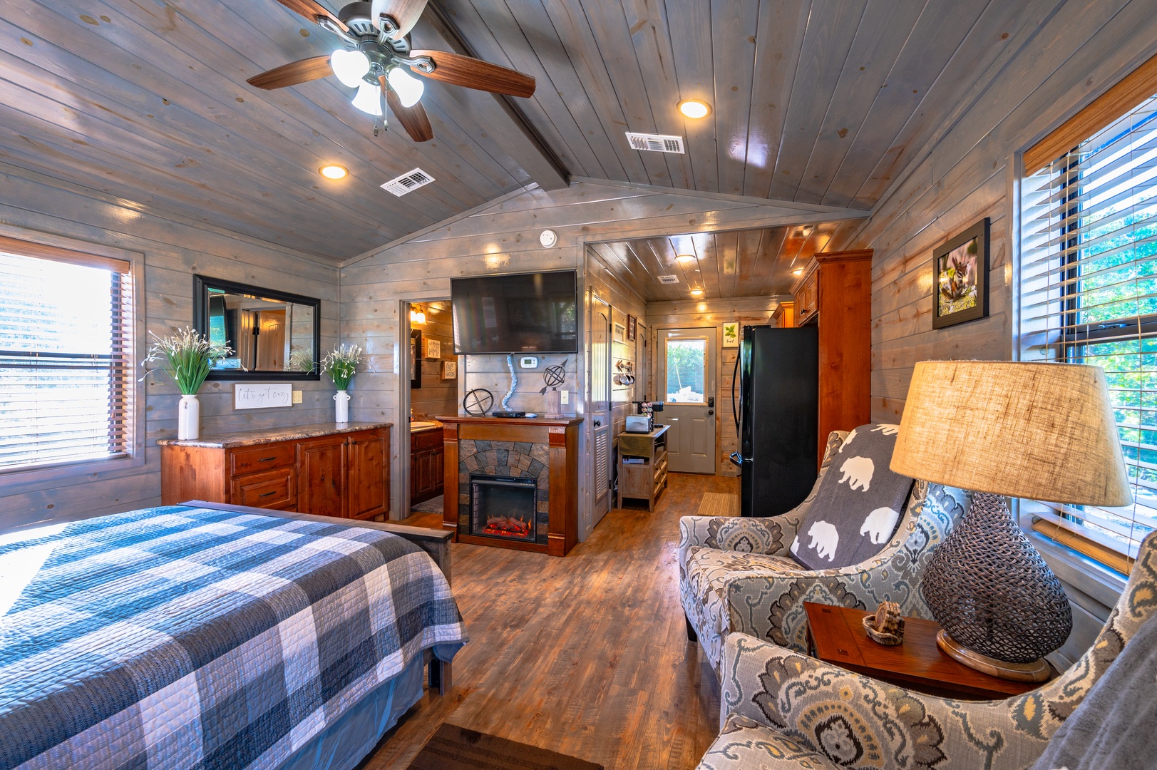 Step into your cozy cabin retreat where rustic wood walls embrace you, a crackling fireplace awaits, and modern comforts blend seamlessly with charm.