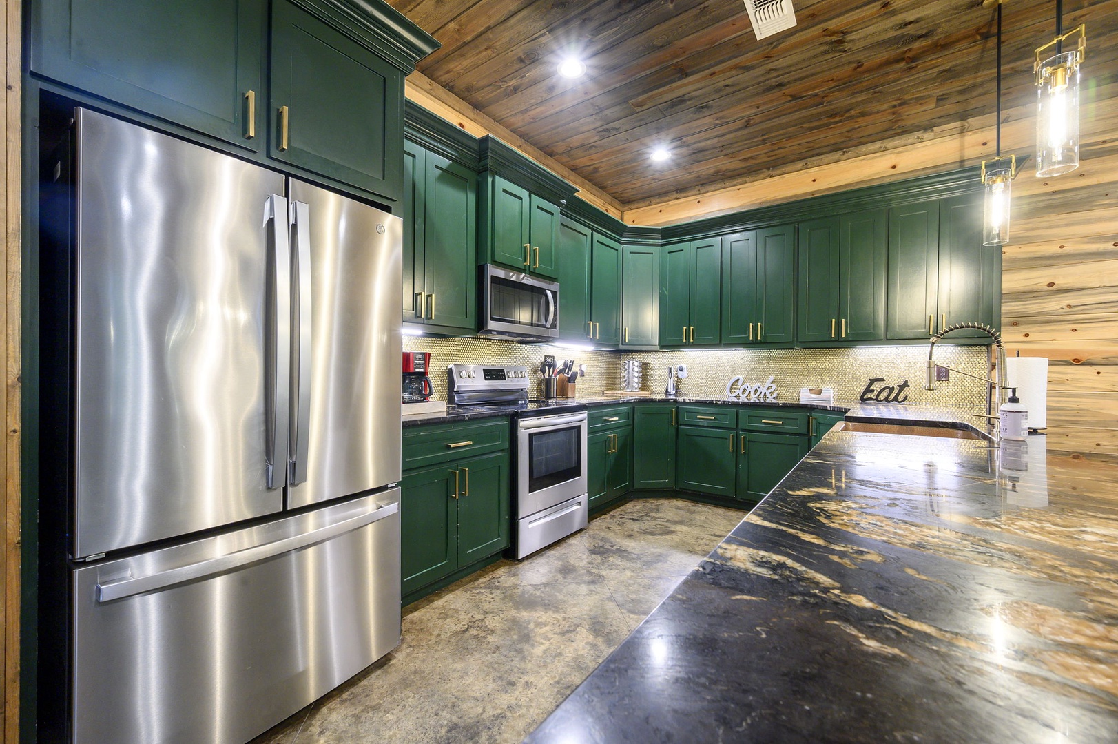 Your dream vacation kitchen awaits with rich green cabinetry, gleaming countertops, and top-of-the-line appliances ready for any culinary adventure you have in mind.
