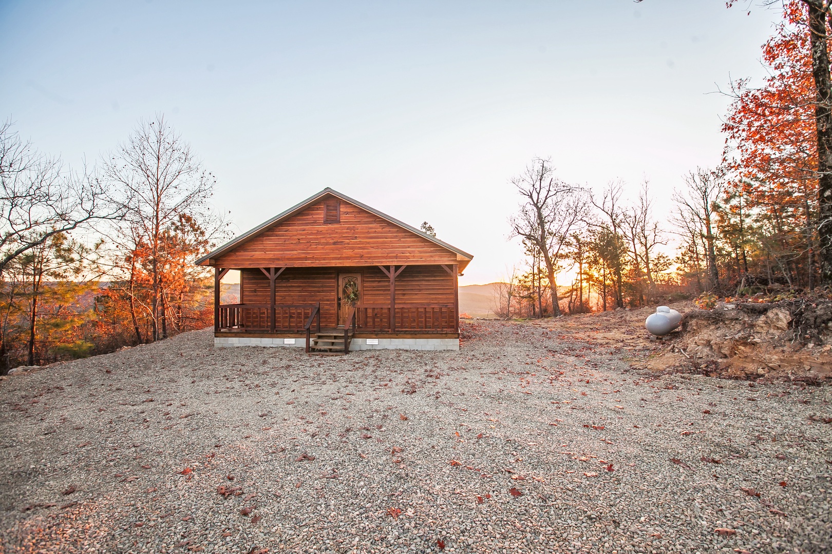 Rustic log cabin nestled among autumn foliage offers a peaceful mountain retreat with stunning seasonal colors.