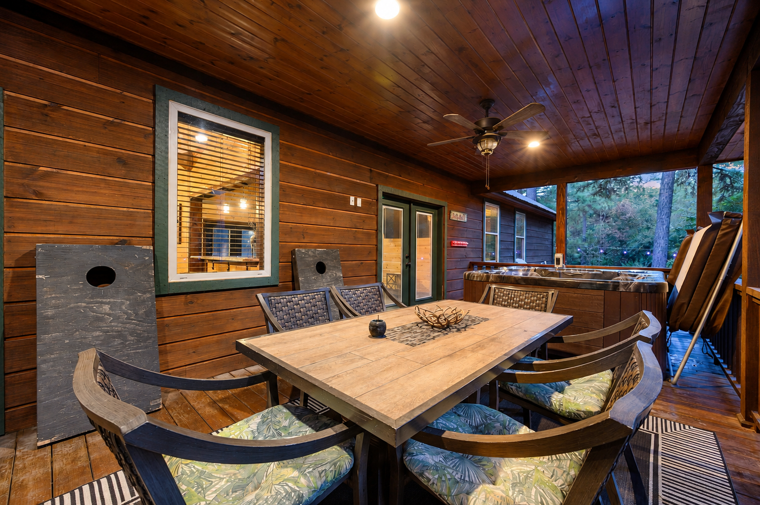 Gather around the covered patio table for meals or games, with a hot tub waiting just beyond. Warm lighting and forest views make this your perfect evening retreat.