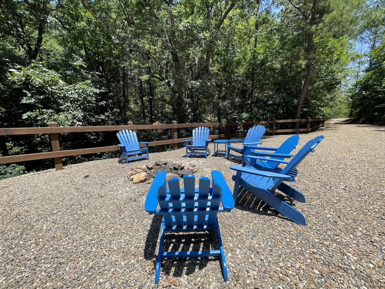 Gather around the fire pit in these bright blue Adirondack chairs, surrounded by towering trees and fresh mountain air—your perfect spot for s'mores and starlit conversations.
