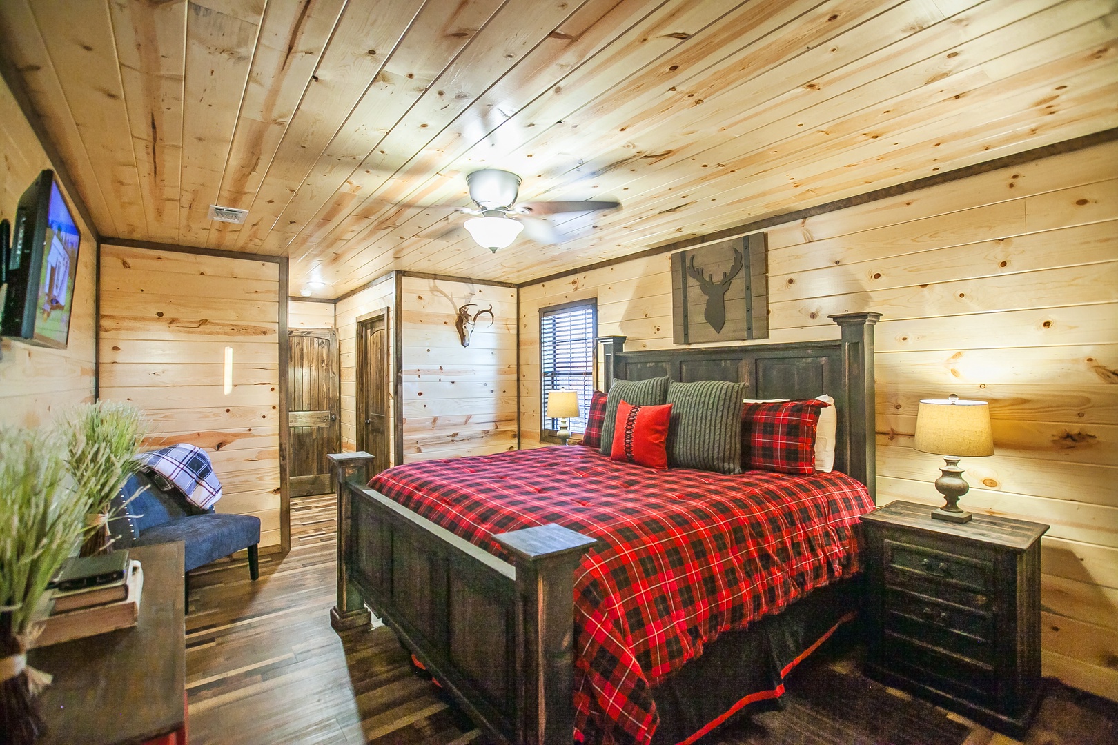 Drift into peaceful sleep in this cozy rustic bedroom with warm wood walls and bold plaid bedding.
