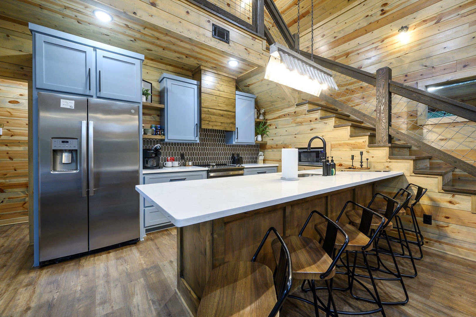 Gather around the spacious kitchen island and enjoy modern conveniences amid warm wood beams and rustic charm. Stainless steel appliances, ample counter space, and stylish seating make this your home away from home.