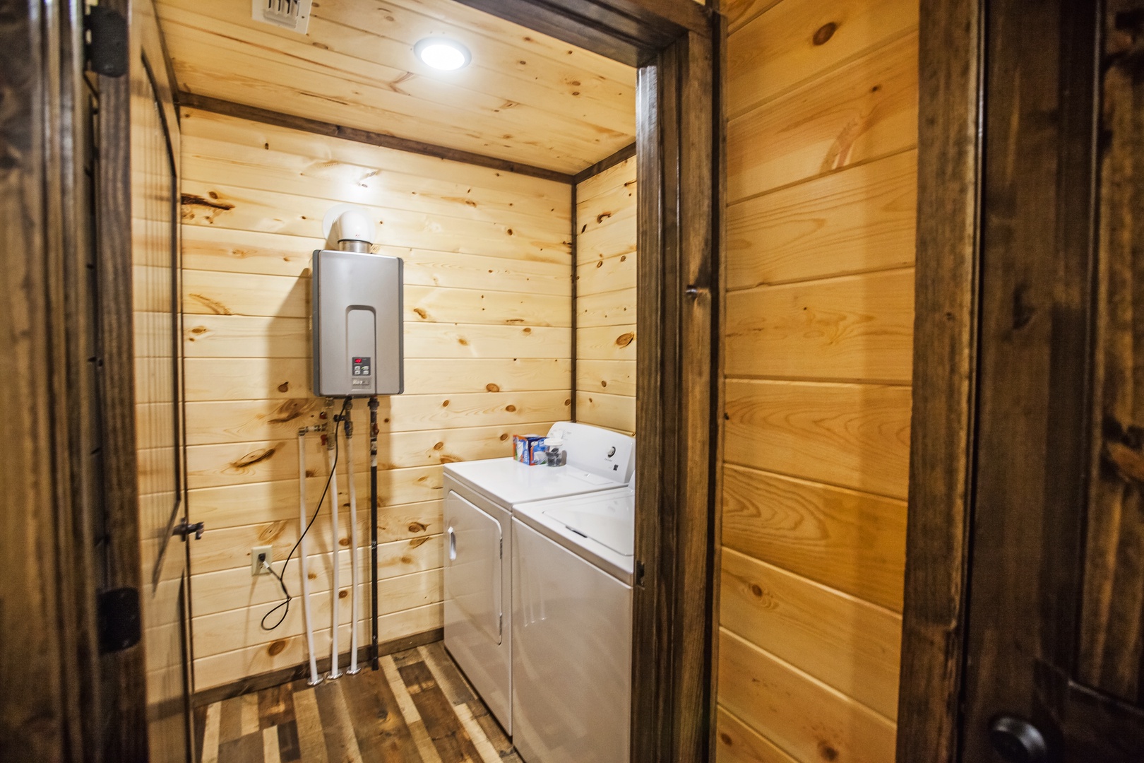 Your cozy laundry room features warm wood paneling and modern appliances for convenient washing during your stay.