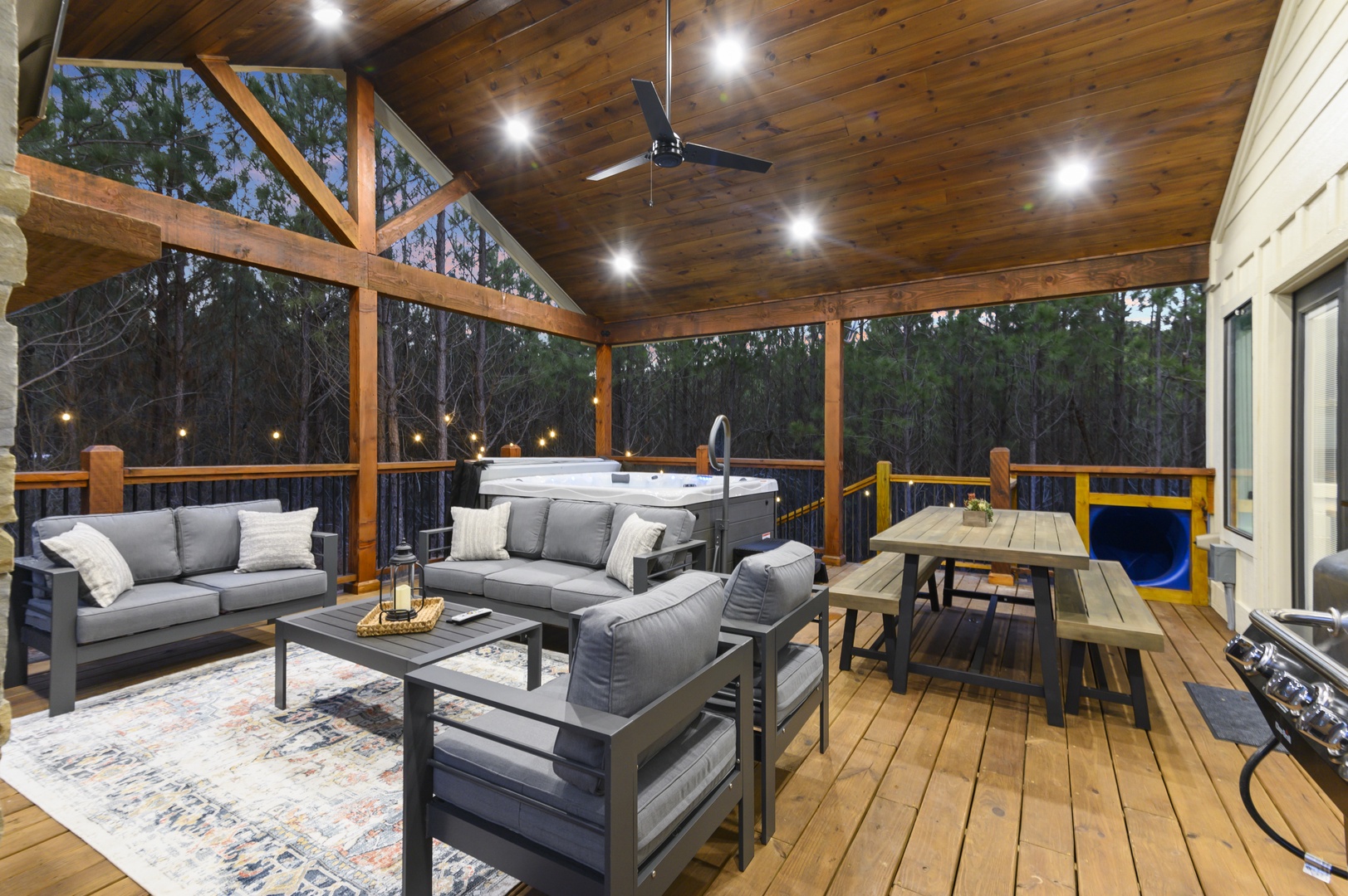 Unwind on your private covered deck with plush seating, hot tub, and dining area surrounded by peaceful forest views.