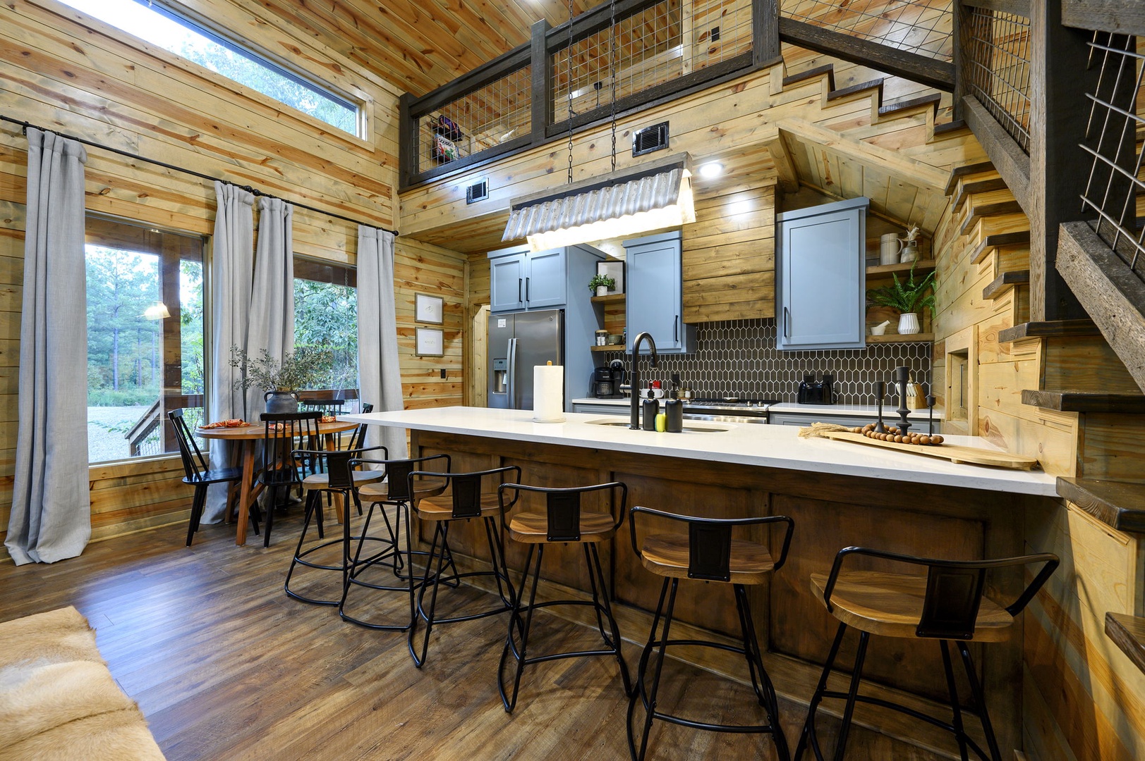 Stylish kitchen island where natural wood meets modern design. Sunlight streams through tall windows, illuminating the open-concept space that blends rustic charm with contemporary comfort.