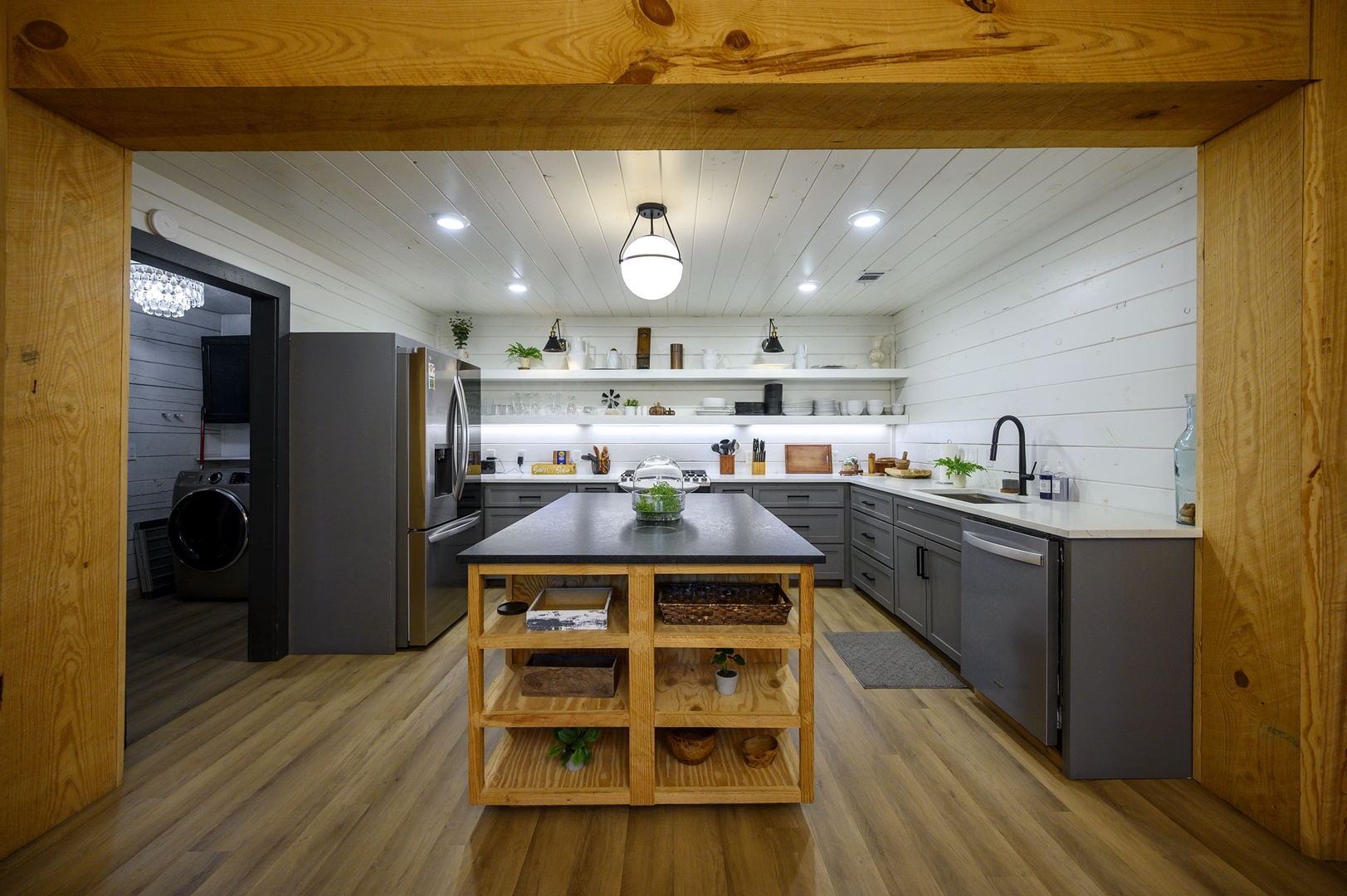 Step into your chef's paradise with sleek gray cabinetry, spacious island, and modern appliances - perfect for creating memorable meals together.