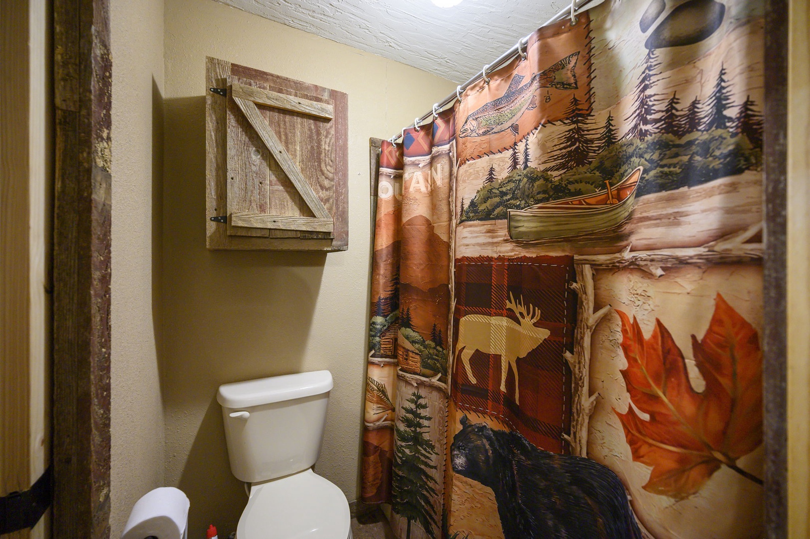 Your rustic bathroom features charming woodland-themed decor, creating a cozy cabin atmosphere for your mountain getaway.