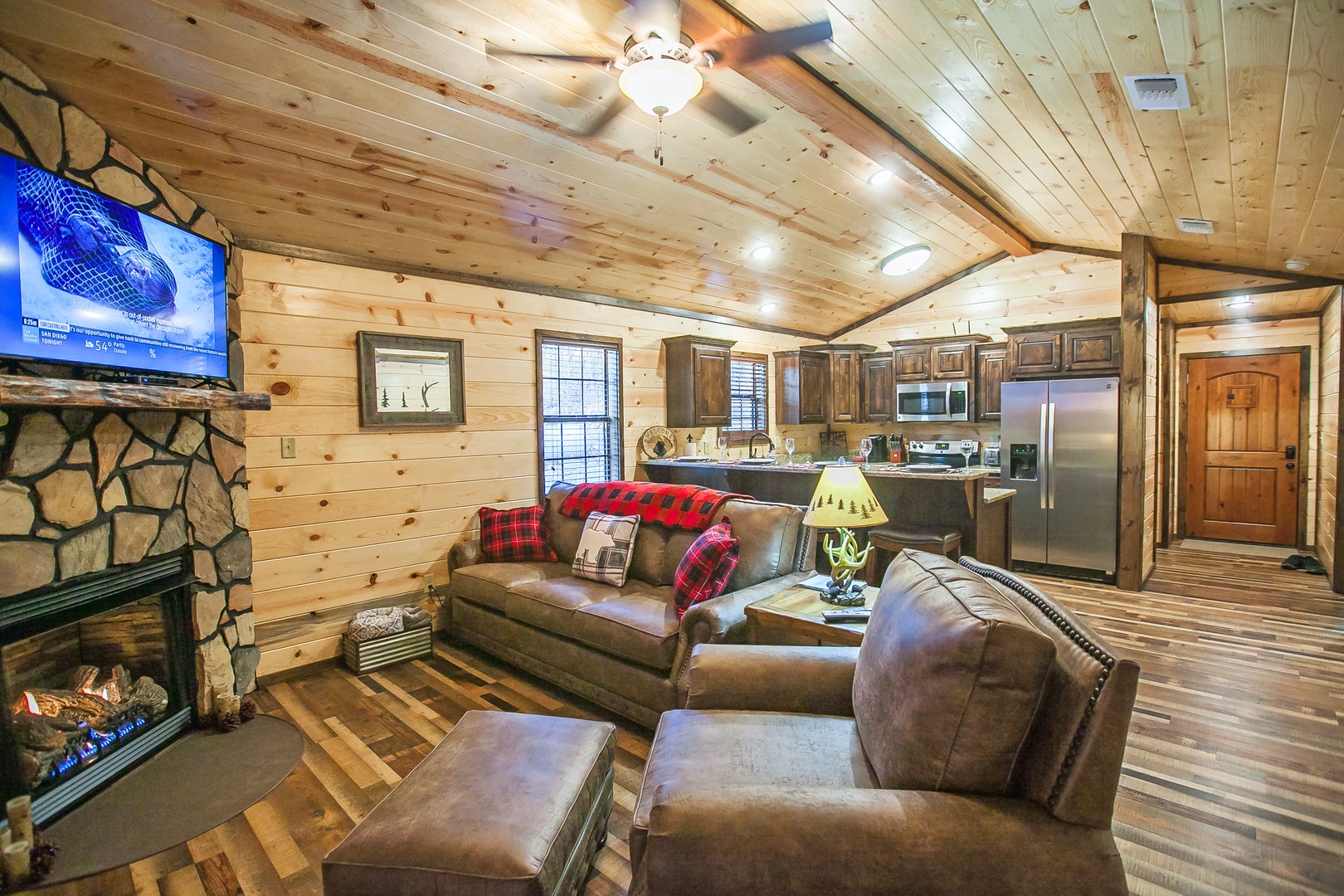 Sink into plush leather seating by your crackling fireplace while the rustic wood beams create perfect cabin ambiance above.