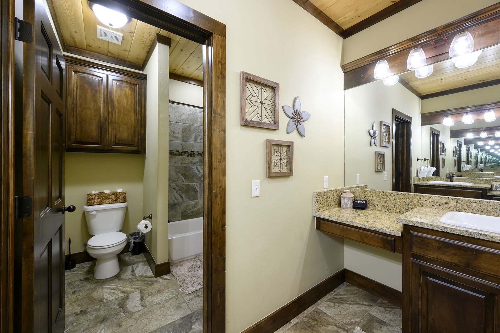 Step into your private bathroom retreat with warm wood cabinetry, gleaming granite counters, and a separate toilet area—everything you need to feel right at home.