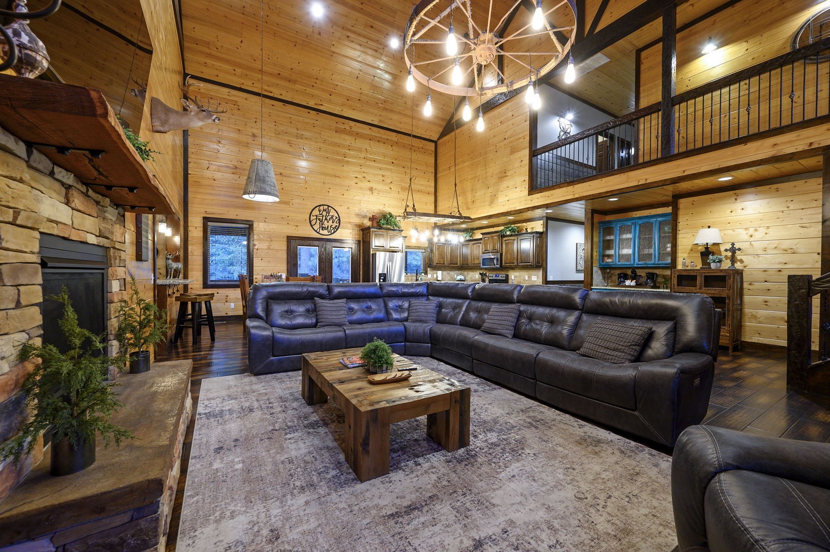 Sink into plush leather seating beneath soaring wood ceilings and rustic wagon wheel chandeliers—your mountain retreat awaits with warmth and room to breathe.