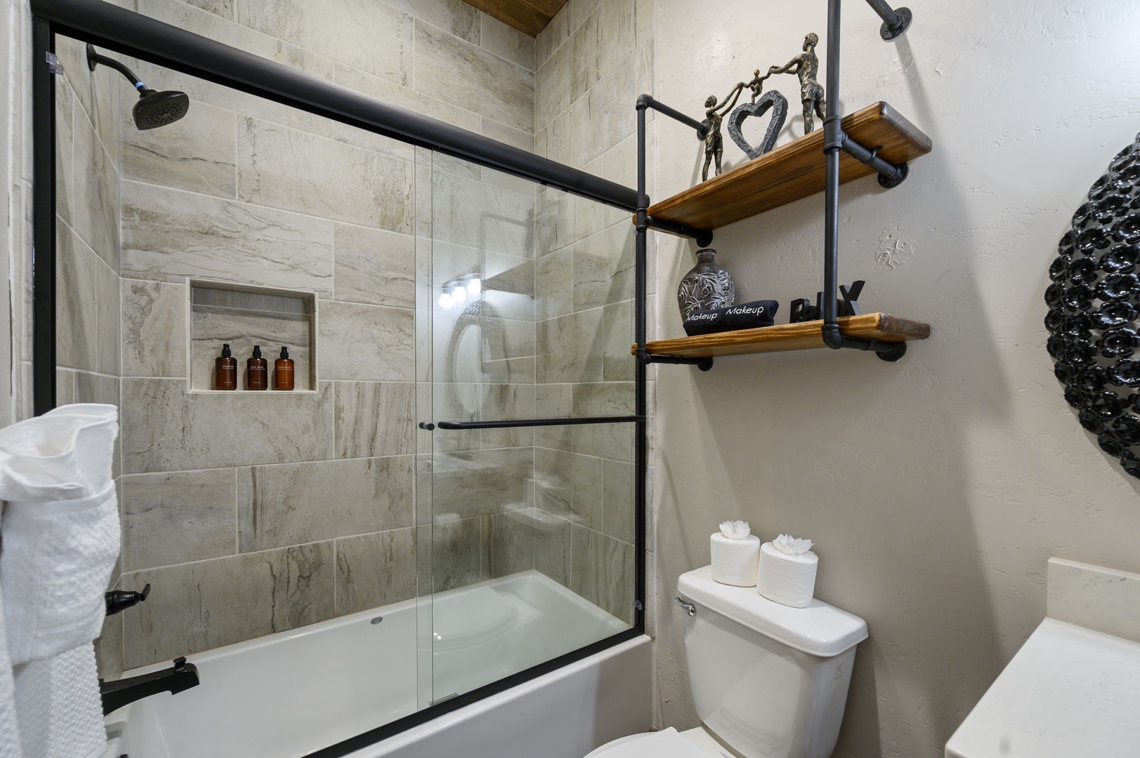 Freshen up in your stylish bathroom with modern fixtures, a sleek glass-enclosed shower, and thoughtful touches like soft towels and curated amenities waiting for you.