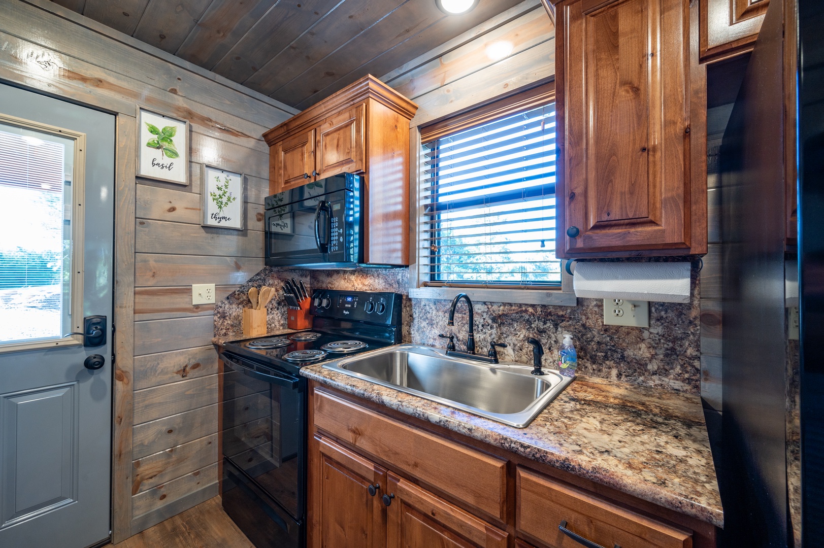 Cook your favorite meals in this fully-equipped kitchen with granite counters, warm wood cabinets, and rustic charm.