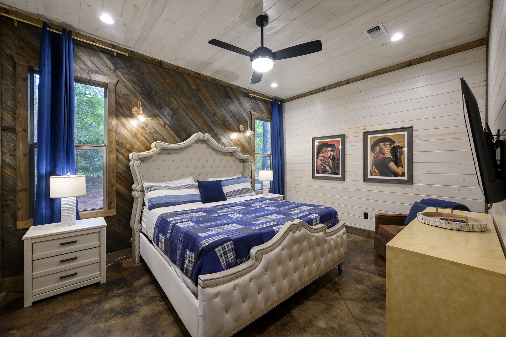 Drift off in your cozy bedroom featuring rustic wood accent walls, plush bedding, and modern ceiling fan to keep you comfortable year-round.