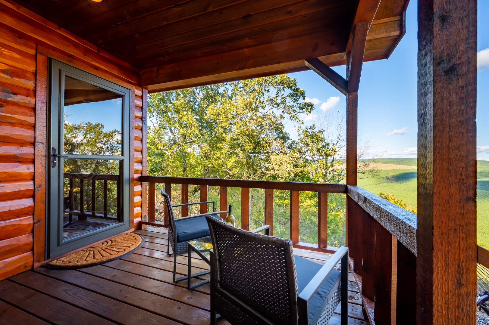 Your private deck overlooks rolling countryside, perfect for morning coffee while listening to birds chirp in the towering trees.