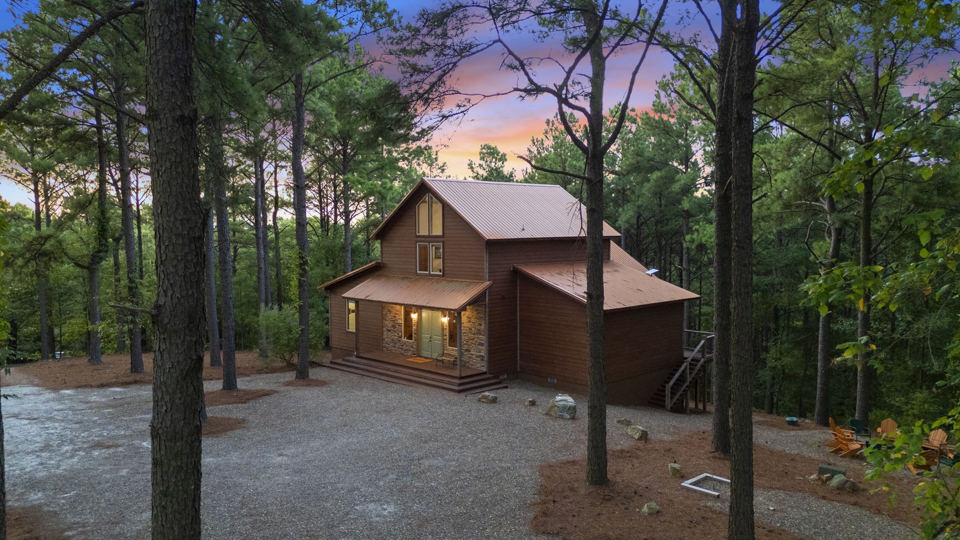 A secluded cabin nestled in towering pines, glowing warmly as twilight settles over the forest. Private parking and natural beauty surround this peaceful retreat.