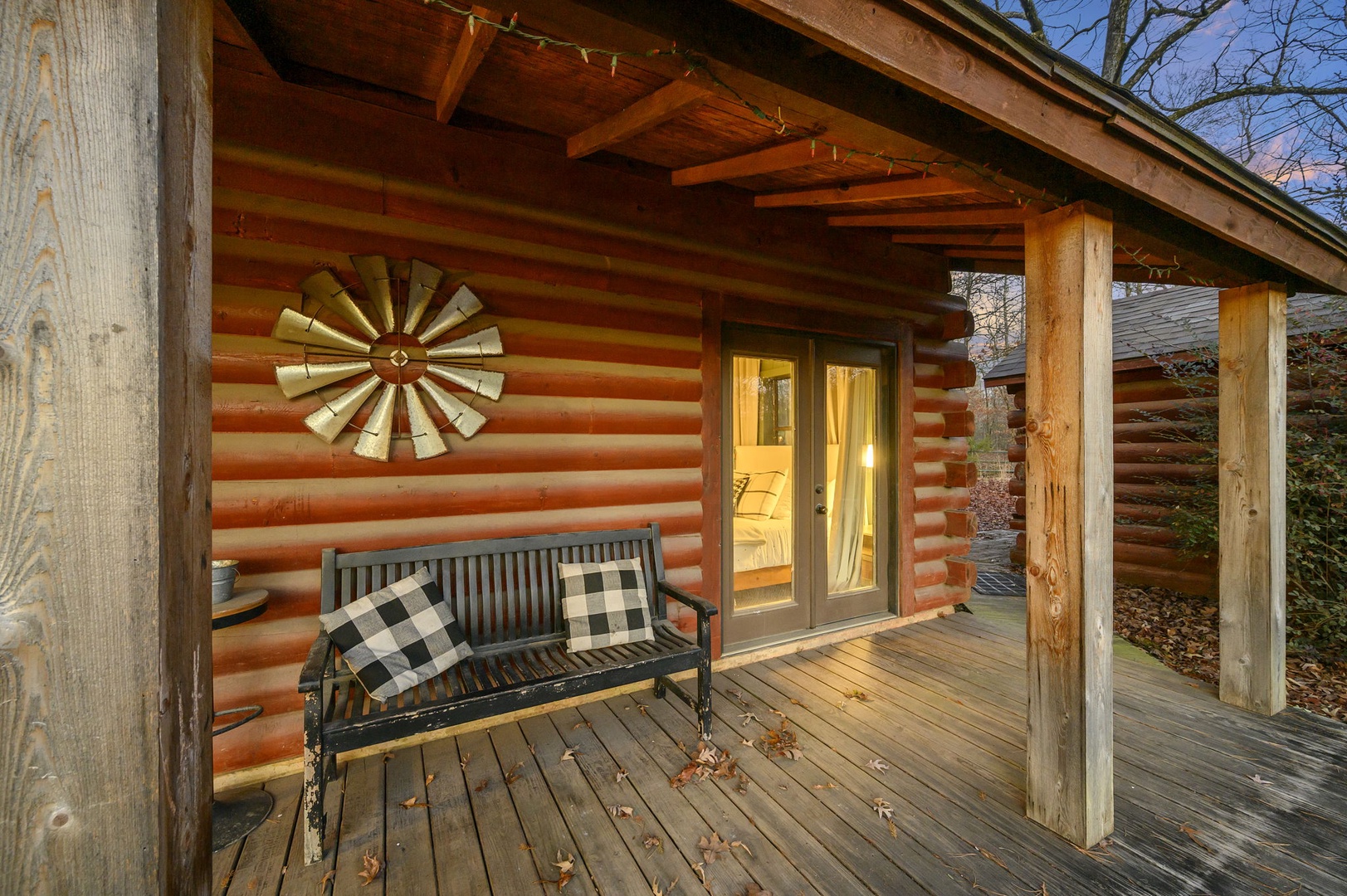 Unwind on your private covered porch with rustic charm, cozy seating, and warm lighting creating the perfect spot to relax.