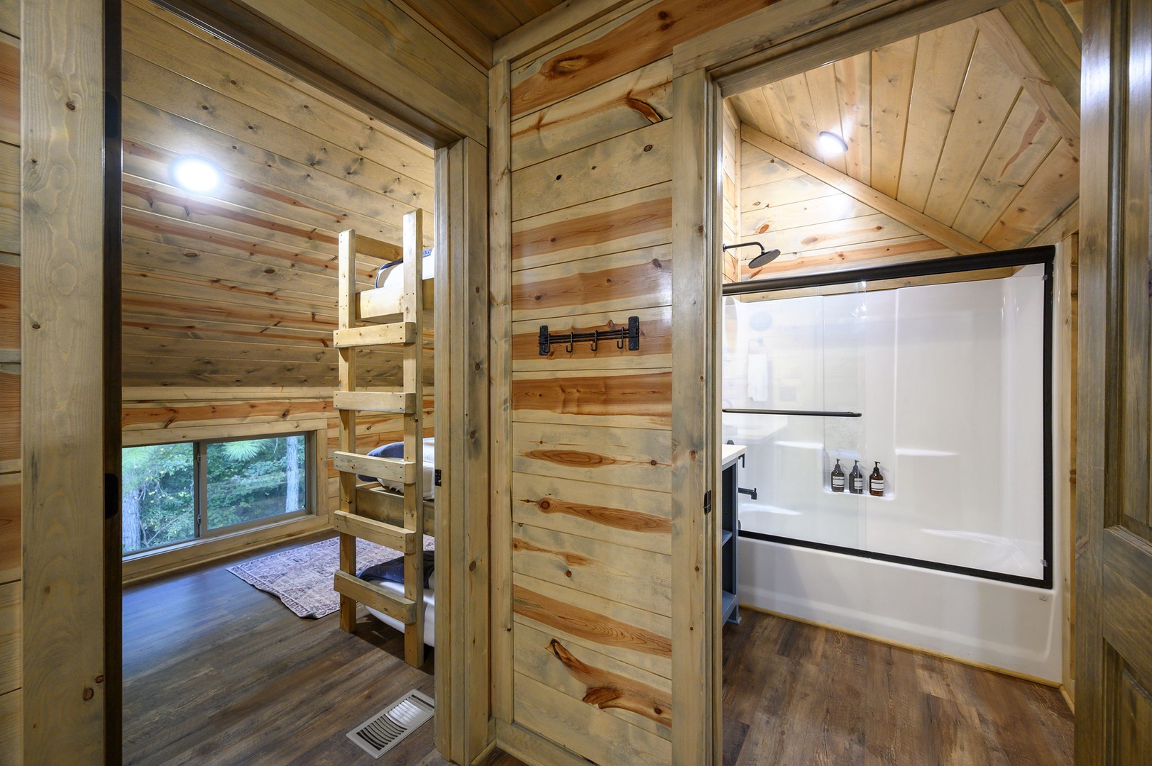 Step into your cozy cabin retreat, where warm wood surrounds you at every turn. The private bathroom features a sleek tub-shower combo, while your bunk room awaits just beyond, perfect for families or groups.