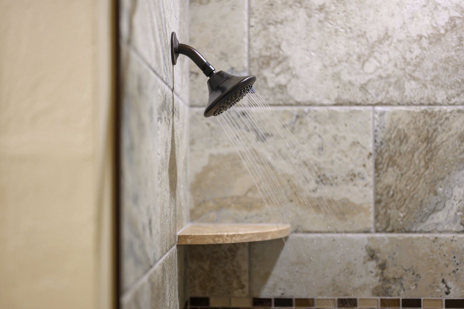 Refresh and recharge under your private rainfall shower with classic bronze fixtures and elegant tiled surround. The built-in corner shelf keeps your essentials within easy reach.